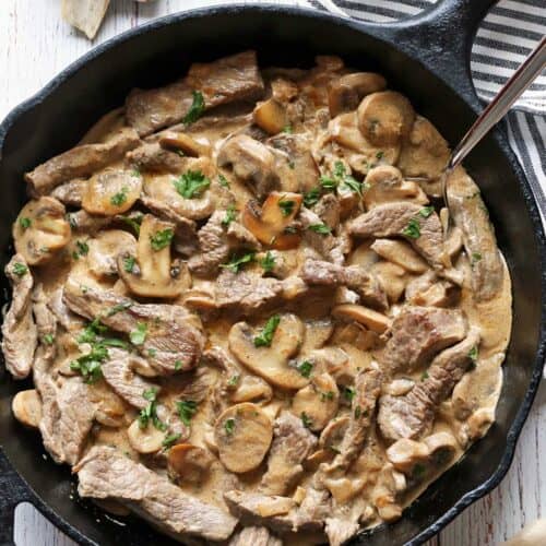 Beef Stroganoff is served in a skillet with a serving spoon.