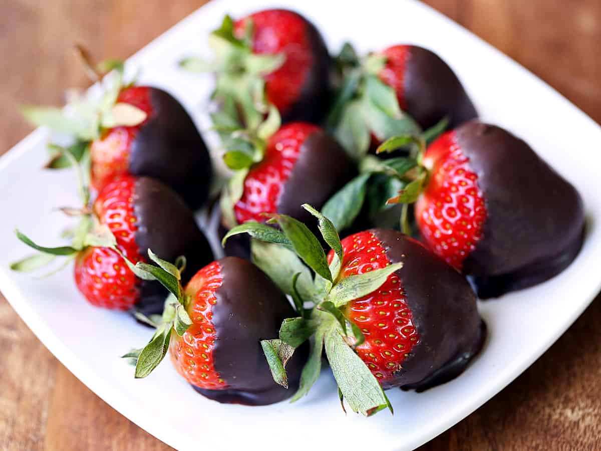 Chocolate covered strawberries served on a white plate.