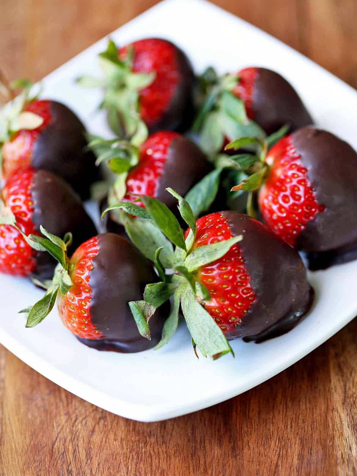 Chocolate-dipped strawberries served on a white plate. 