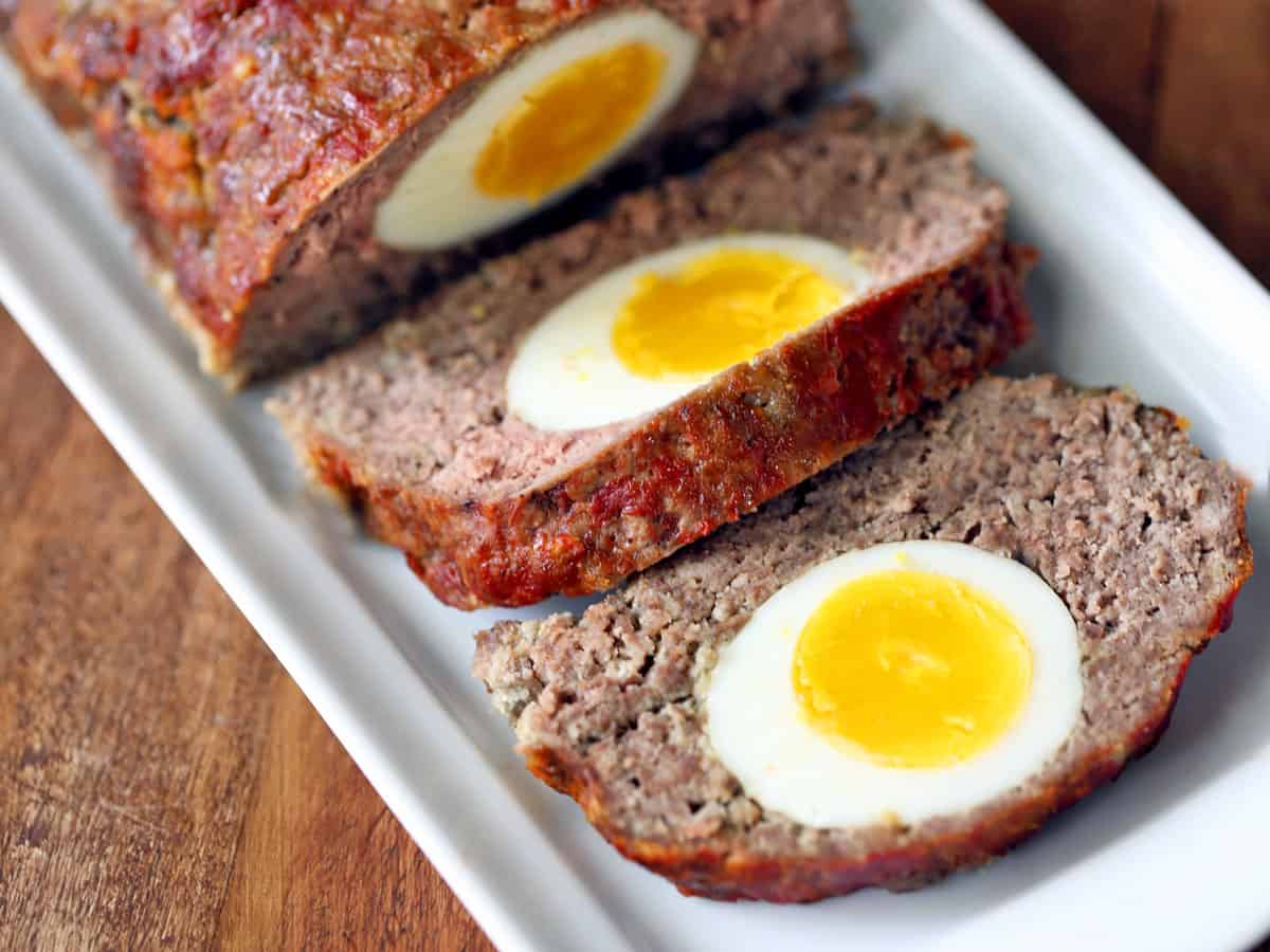 Egg stuffed meatloaf (klops) served on a white tray. 