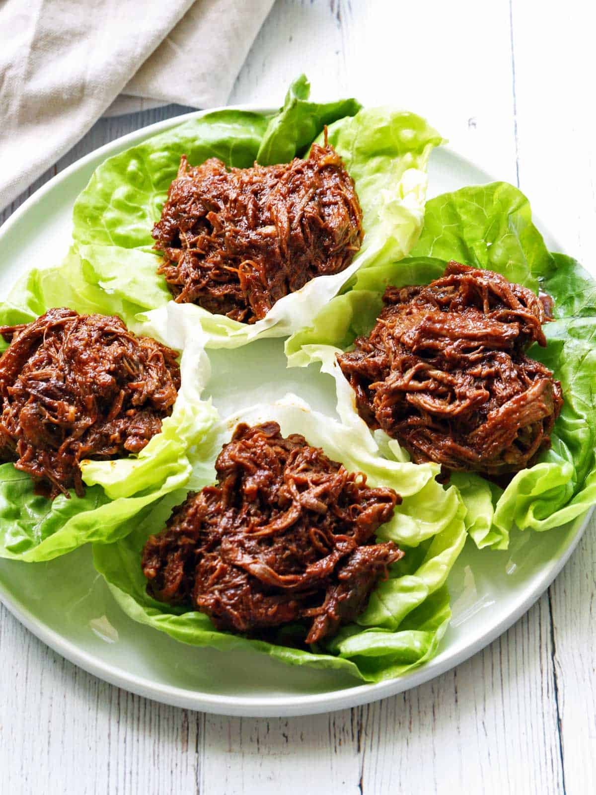 Pulled beef served in lettuce wraps with a napkin. 