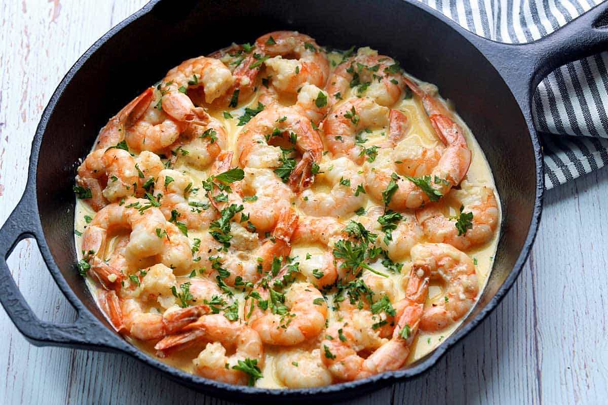 Shrimp in cream sauce served in a cast-iron skillet. 
