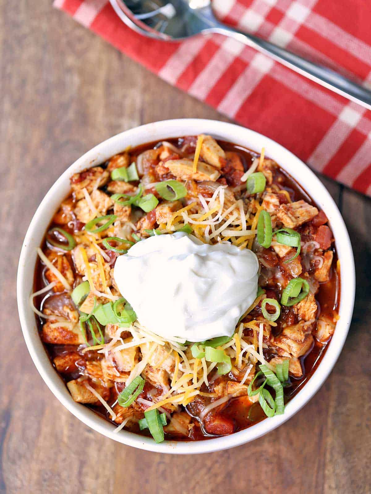 Turkey chili served in a bowl, topped with a dollop of sour cream. 