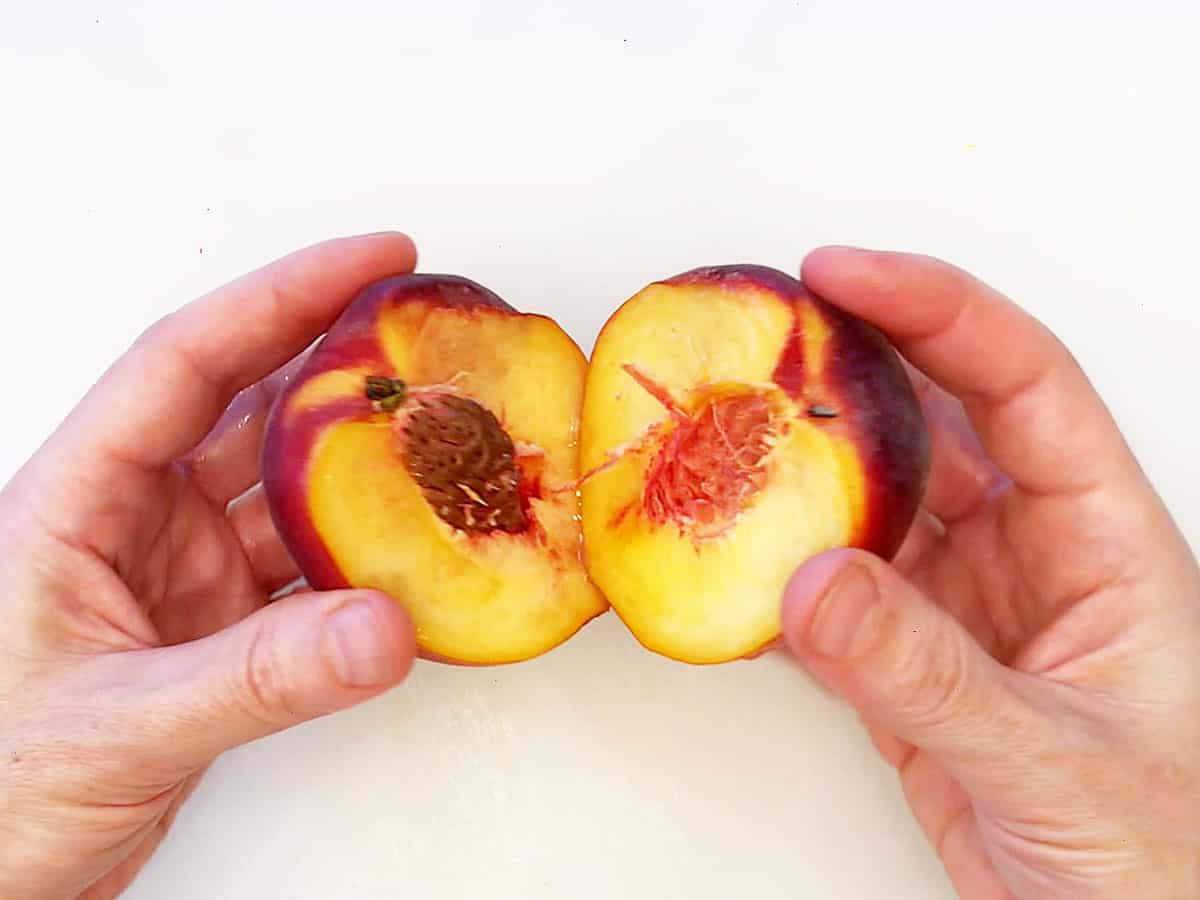 Cutting a peach open.