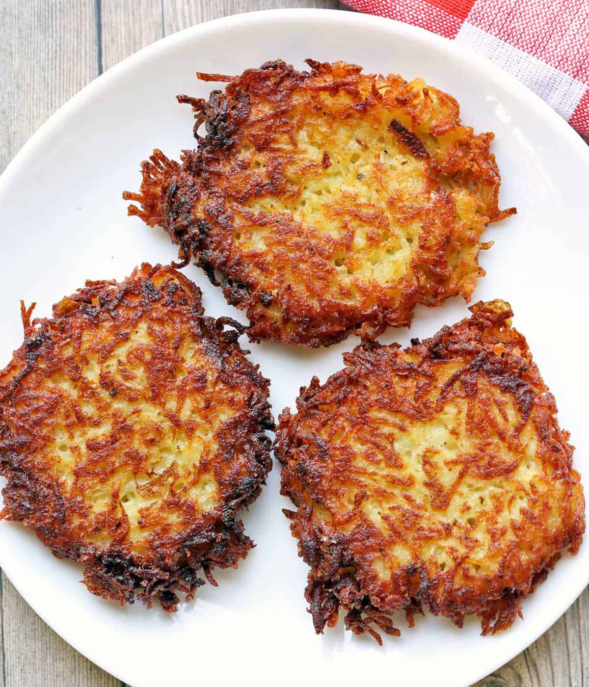 Three latkes served on a white plate. 