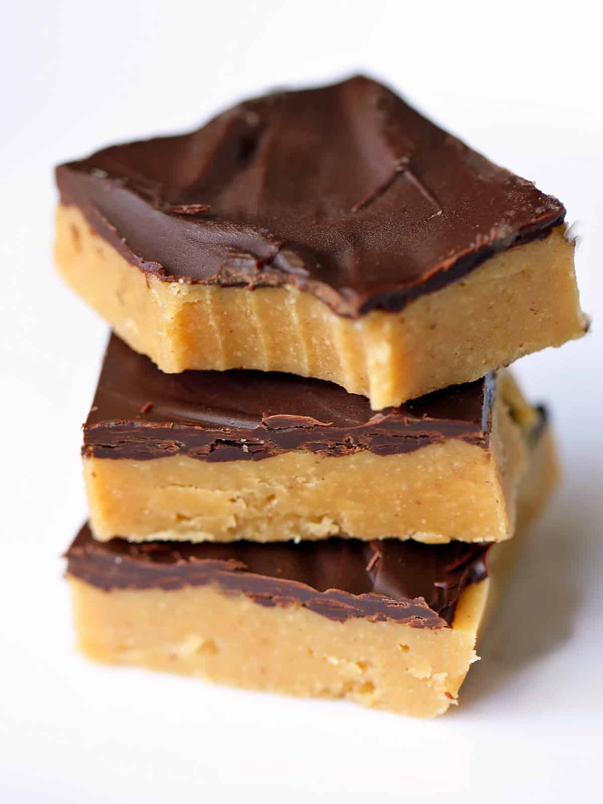 Keto peanut butter bars stacked on a white plate. 