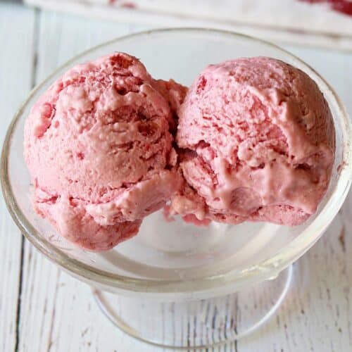 Raspberry frozen yogurt served in a glass dessert bowl.