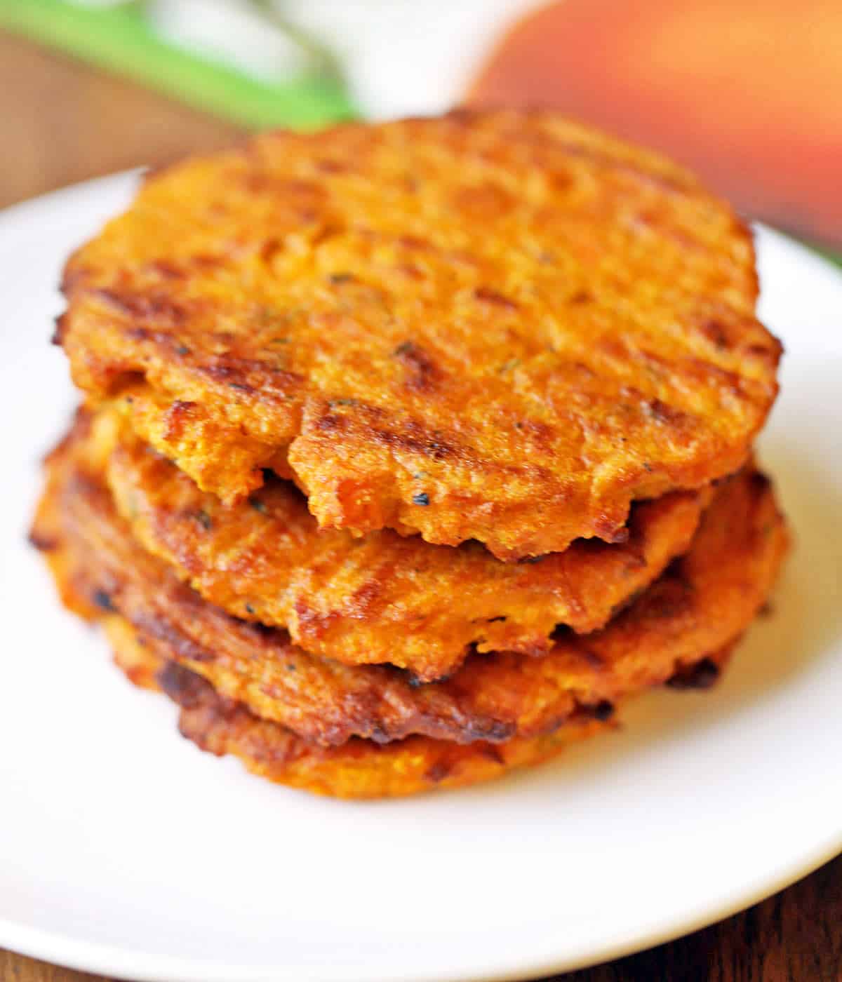 Sweet potato patties stacked on a white plate. 