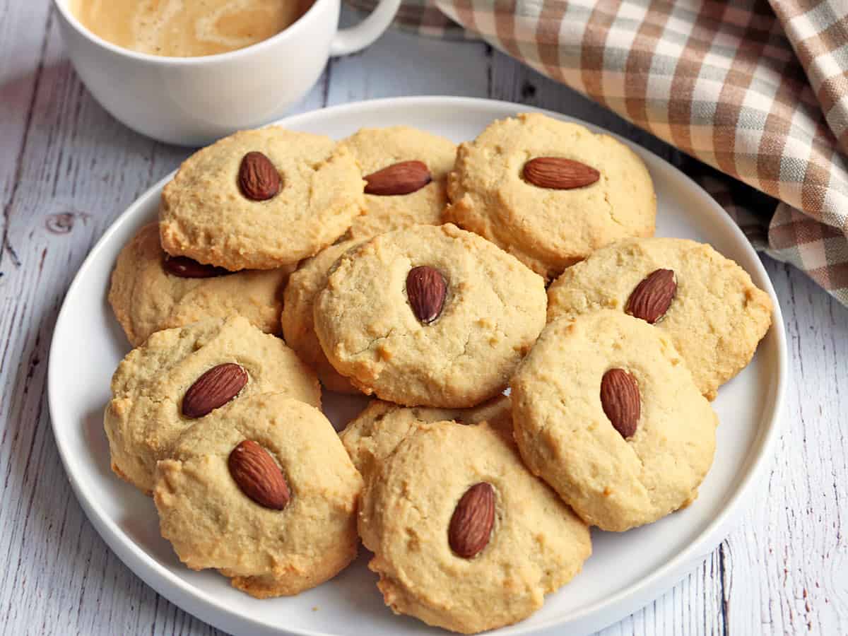 Almond flour cookies served on a white plate with coffee and a napkin. 