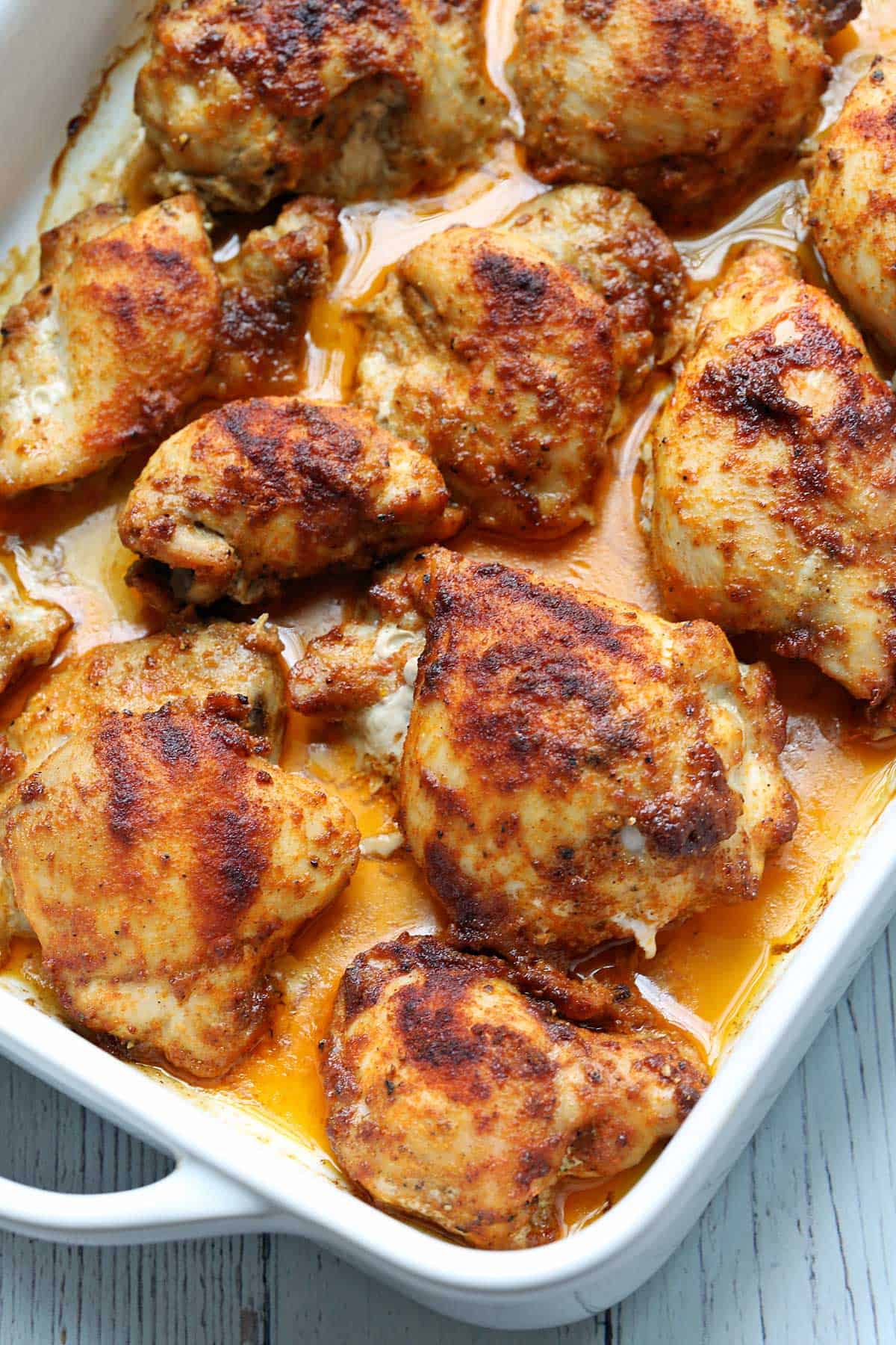 Baked boneless skinless chicken thighs in a baking dish.