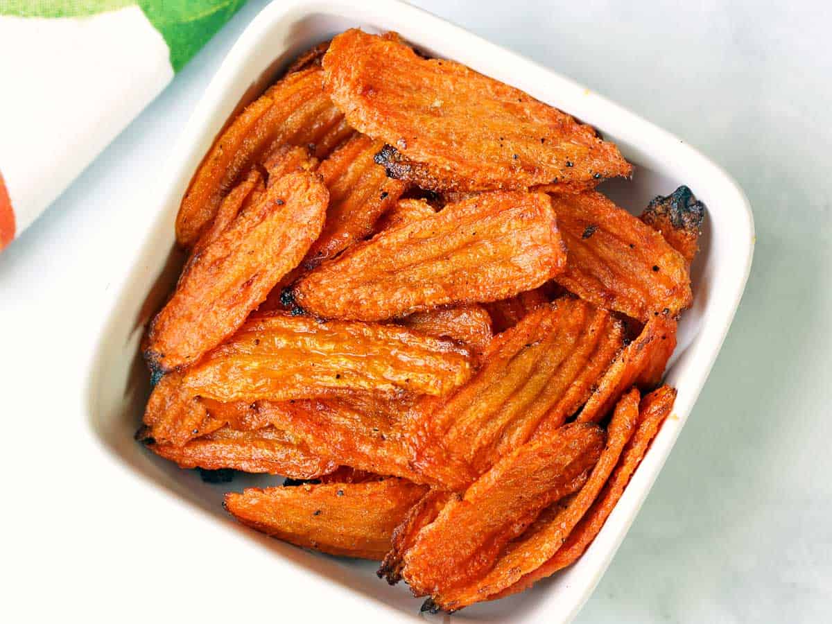 Carrot chips served in a white bowl. 