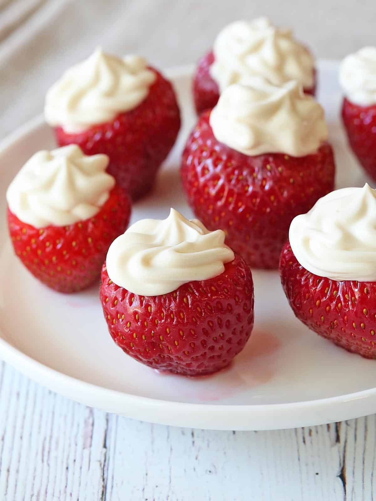 Cheesecake stuffed strawberries  served on a white plate. 