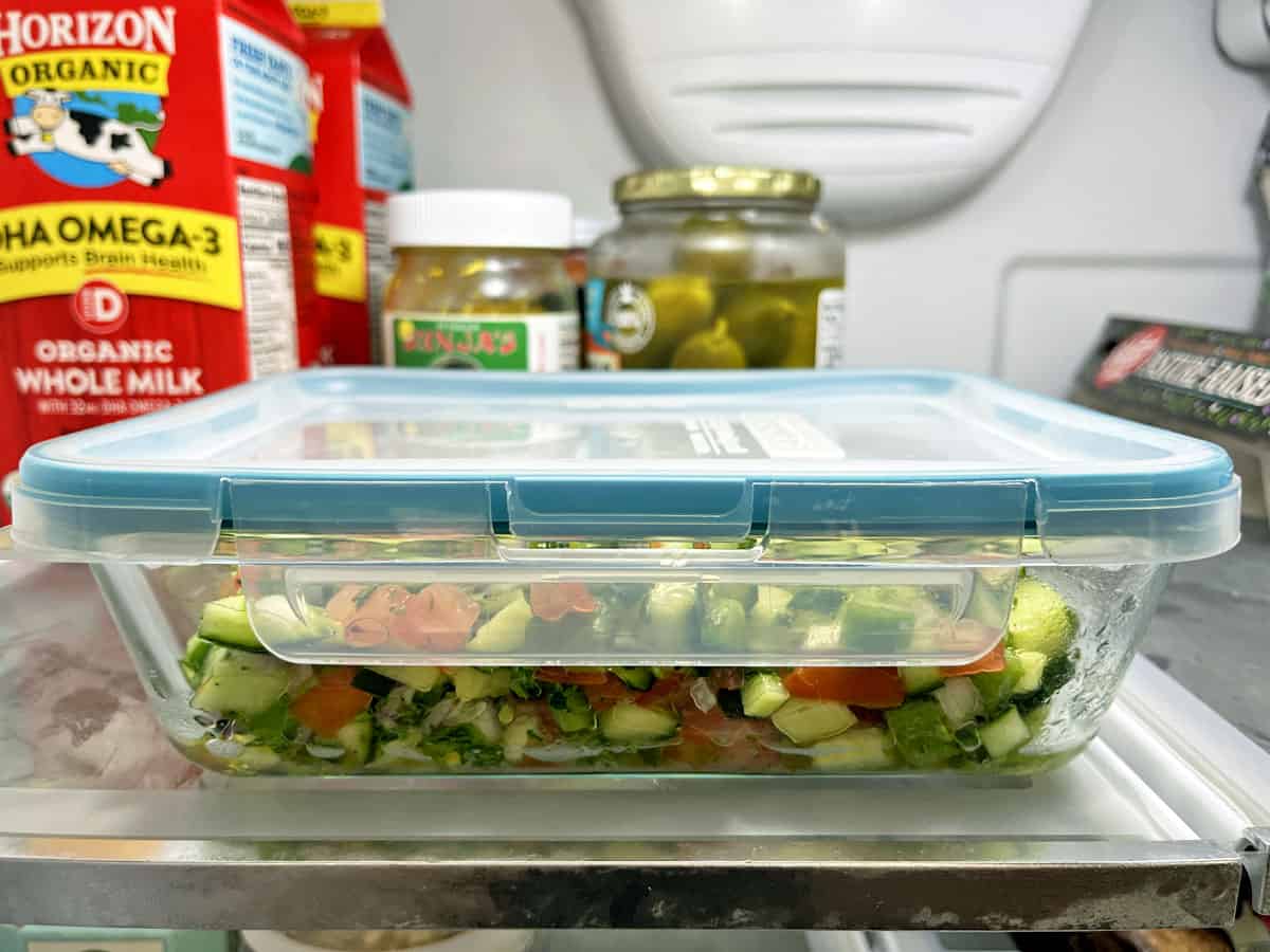 Leftover Israeli salad stored in an airtight container in the fridge. 