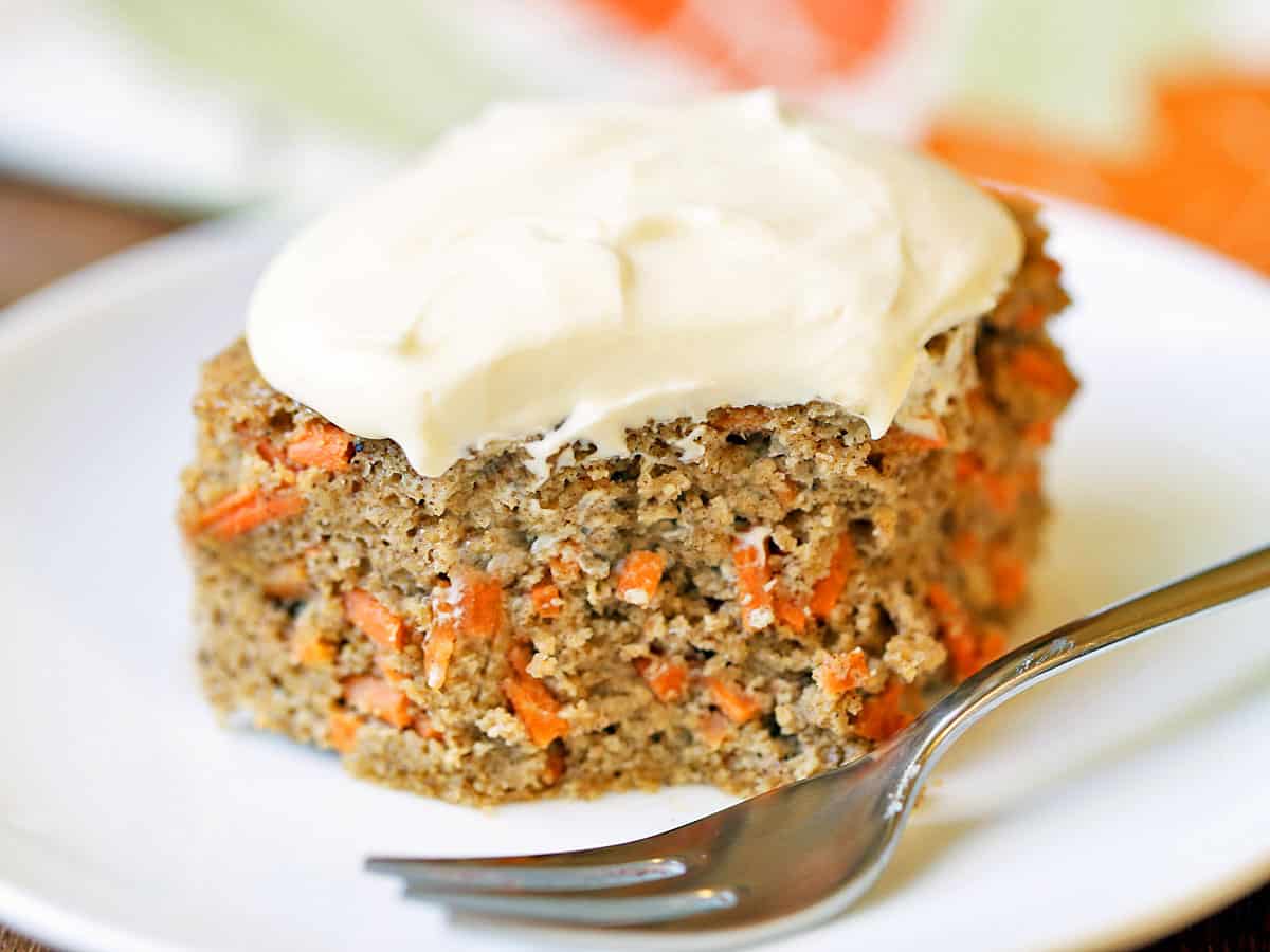 A slice of keto carrot cake topped with frosting. 