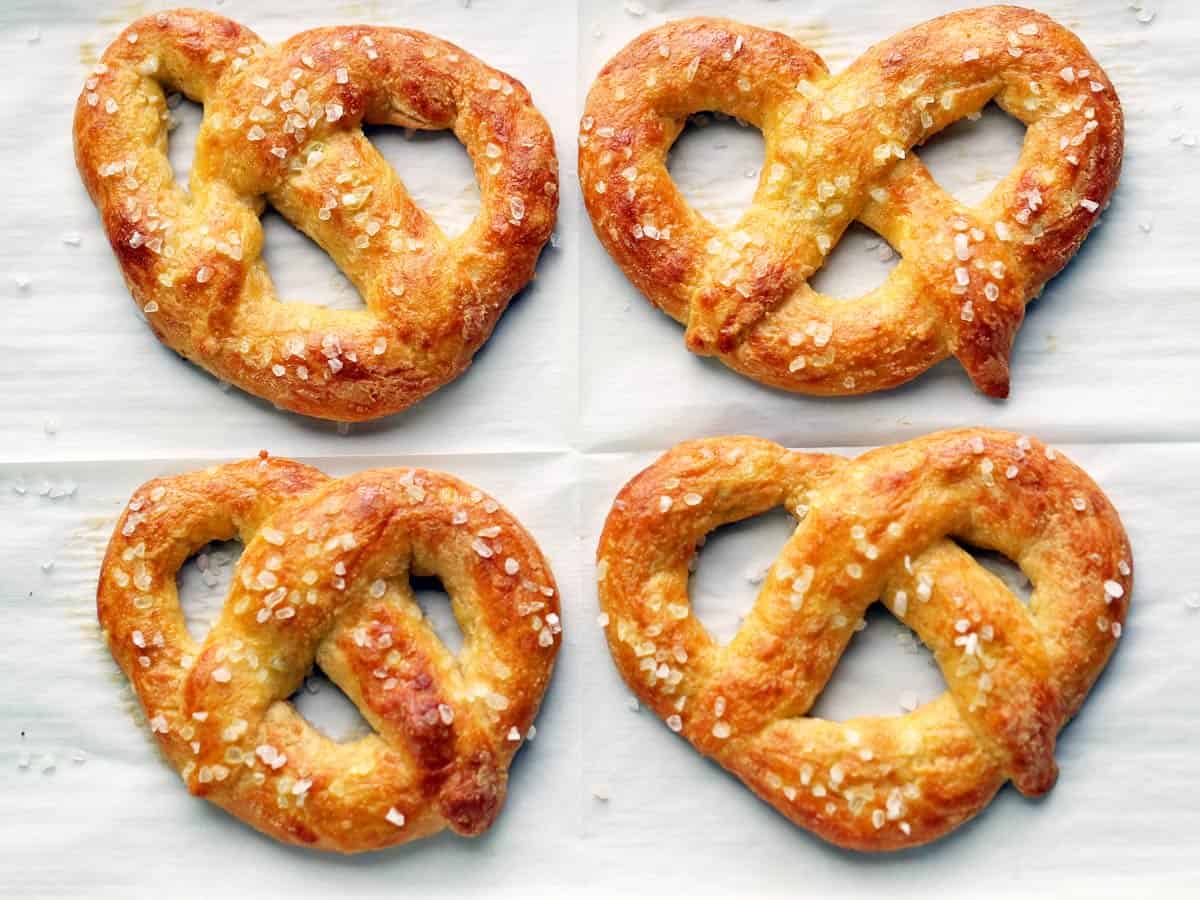 Cuatro pretzels keto fotografiados en una bandeja para hornear forrada de pergamino. 