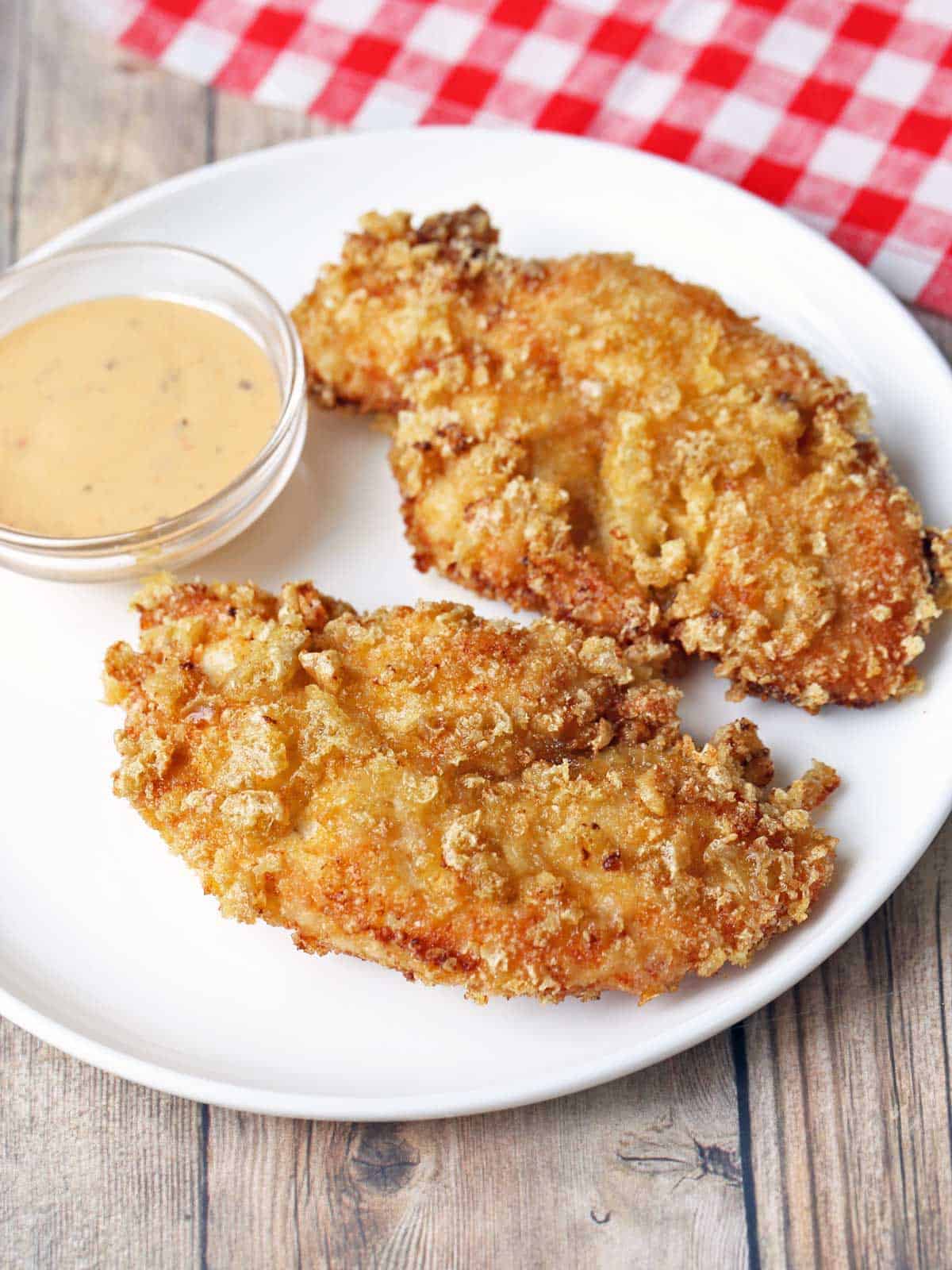 Pork rind chicken tenders served with a dipping sauce. 