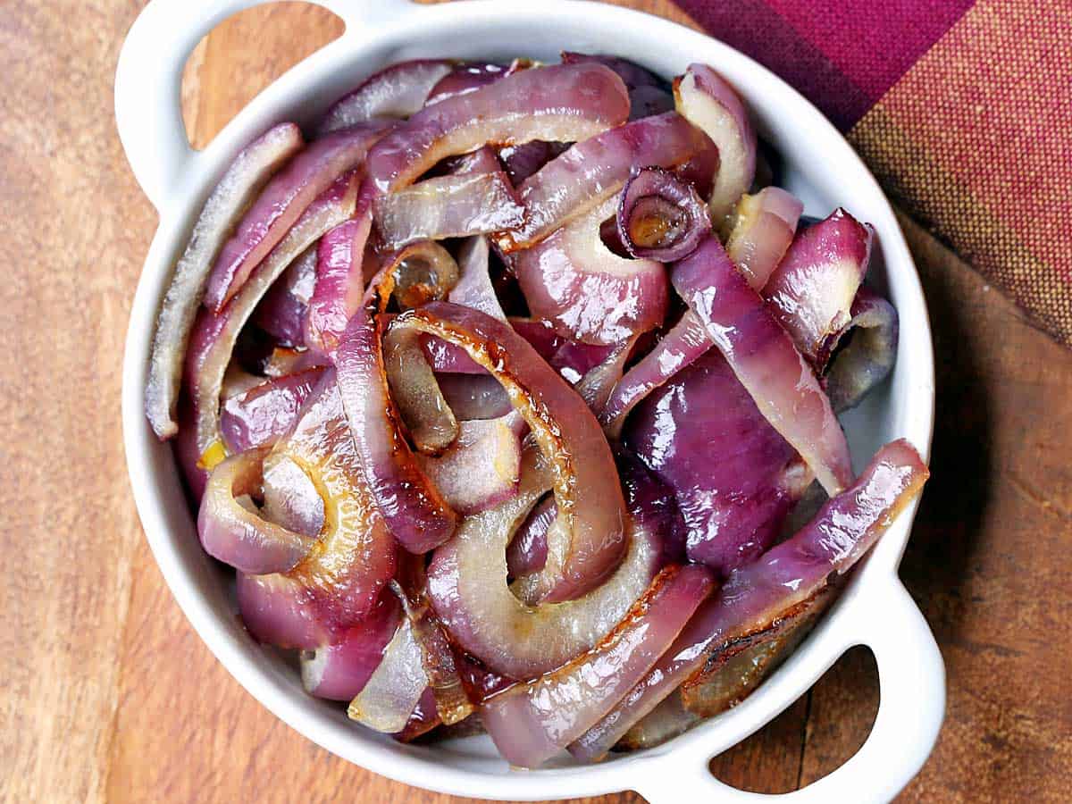 Roasted red onions served in a white bowl. 