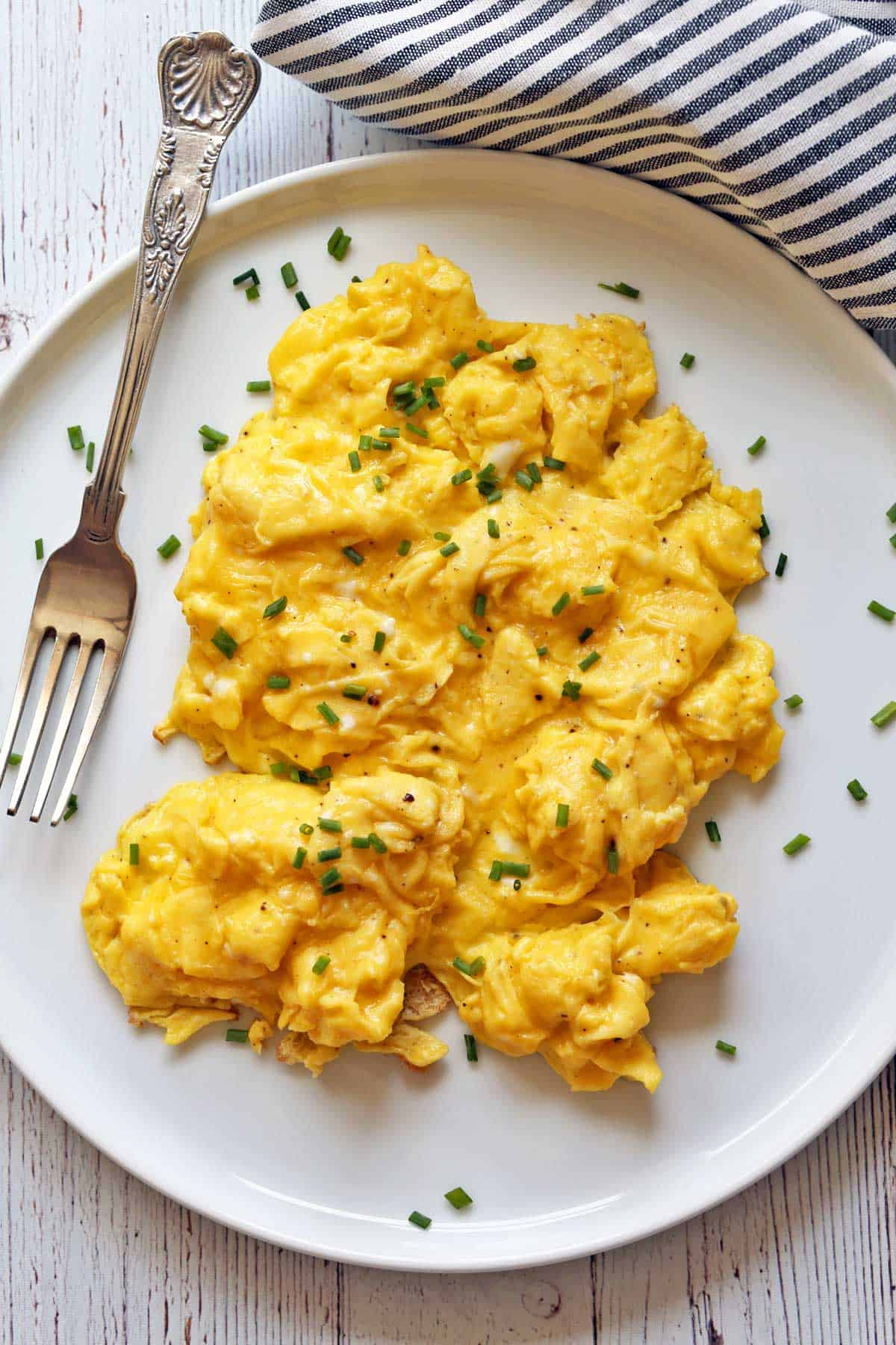 Scrambled eggs served on a white plate. 