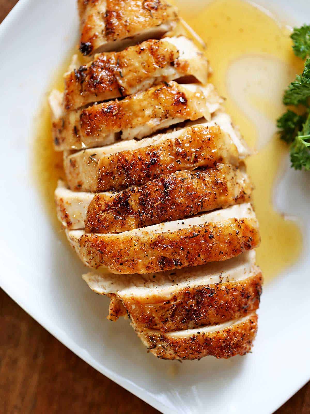 Skin-on chicken breast served on a white plate. 