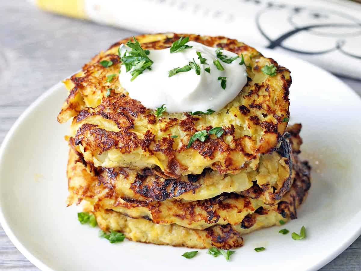 Yellow squash fritters served on a white plate. 