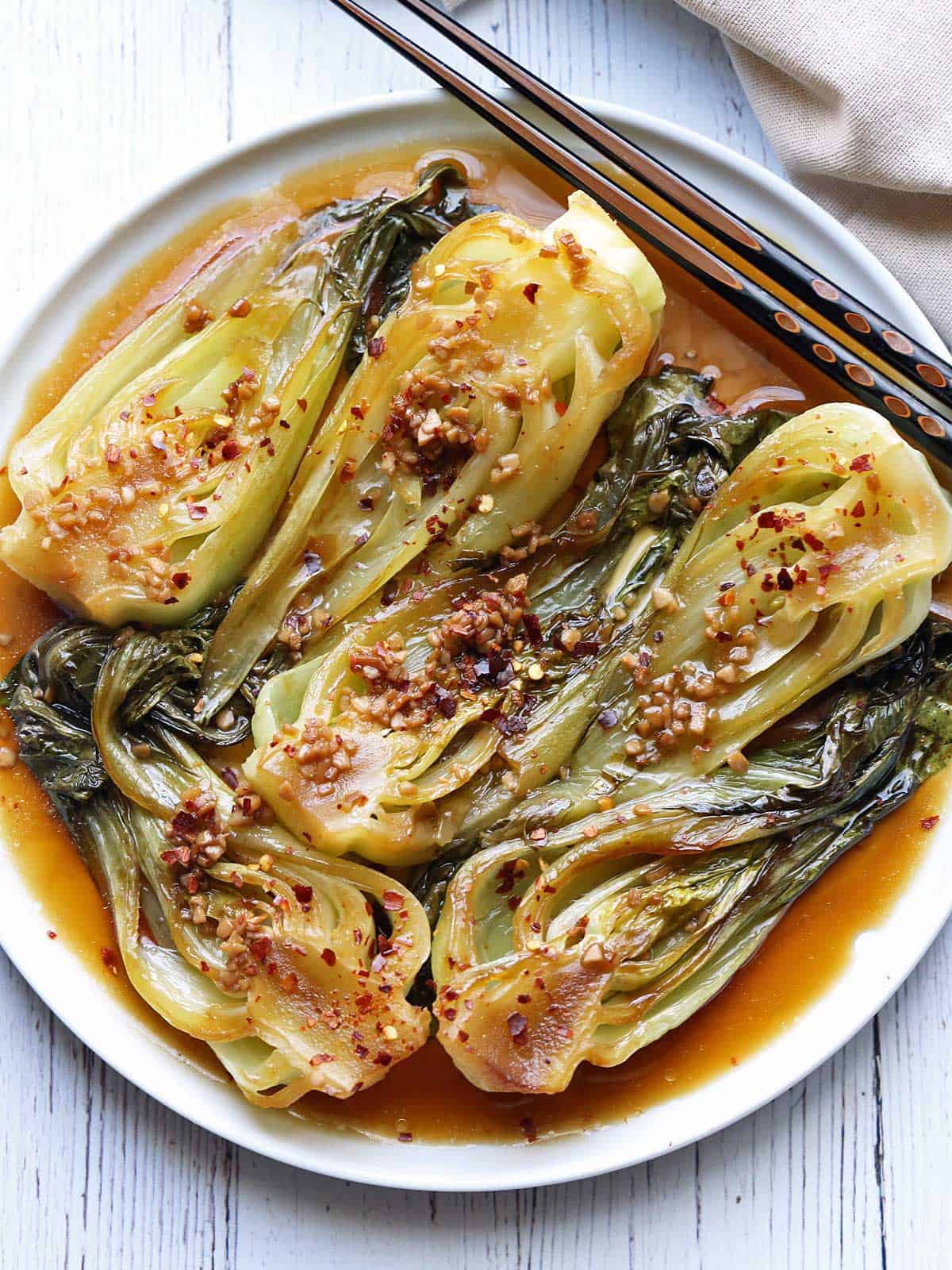 Sauteed bok choy is topped with red pepper flakes. 
