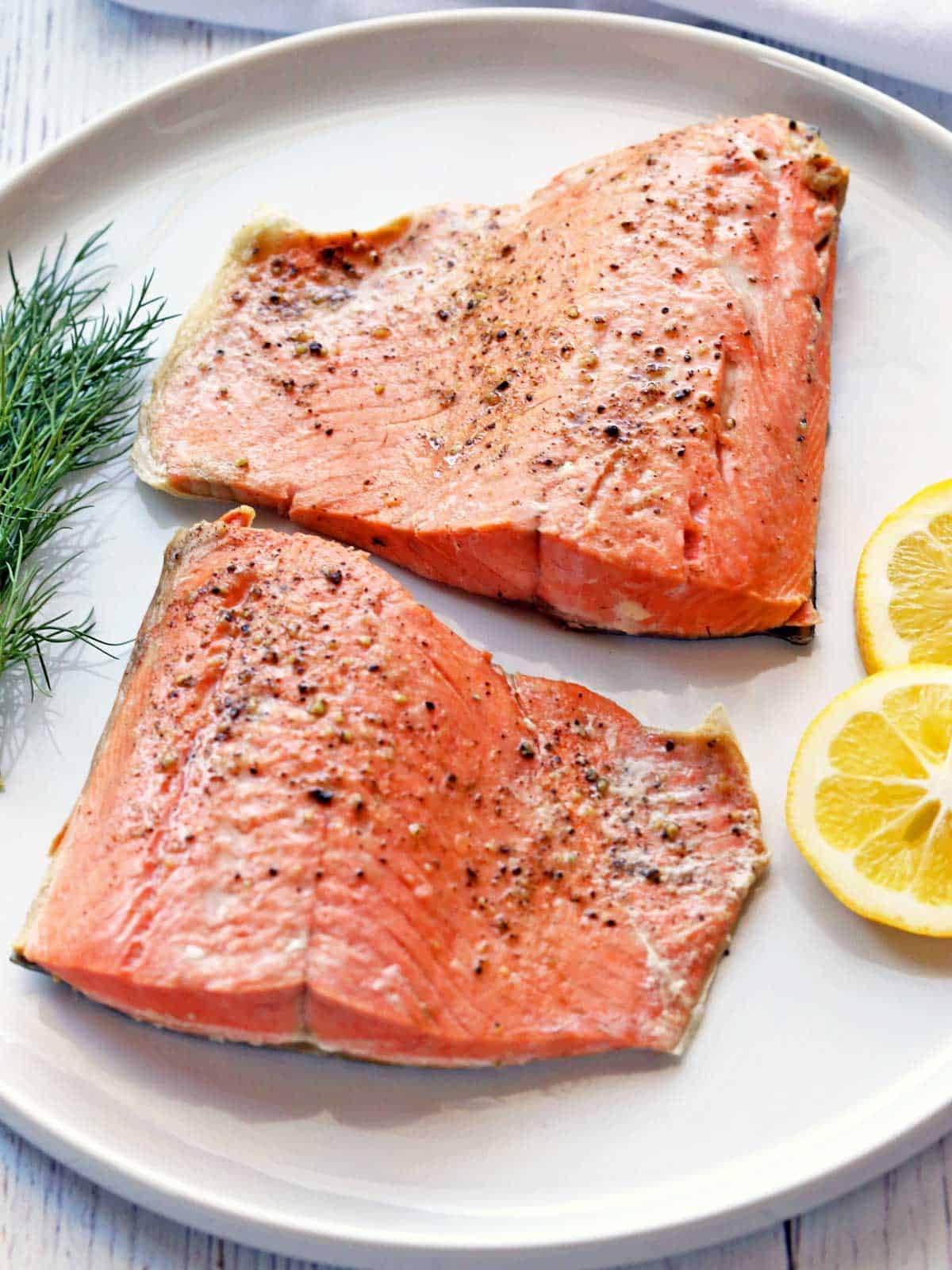 Poached salmon served with lemon slices and dill. 