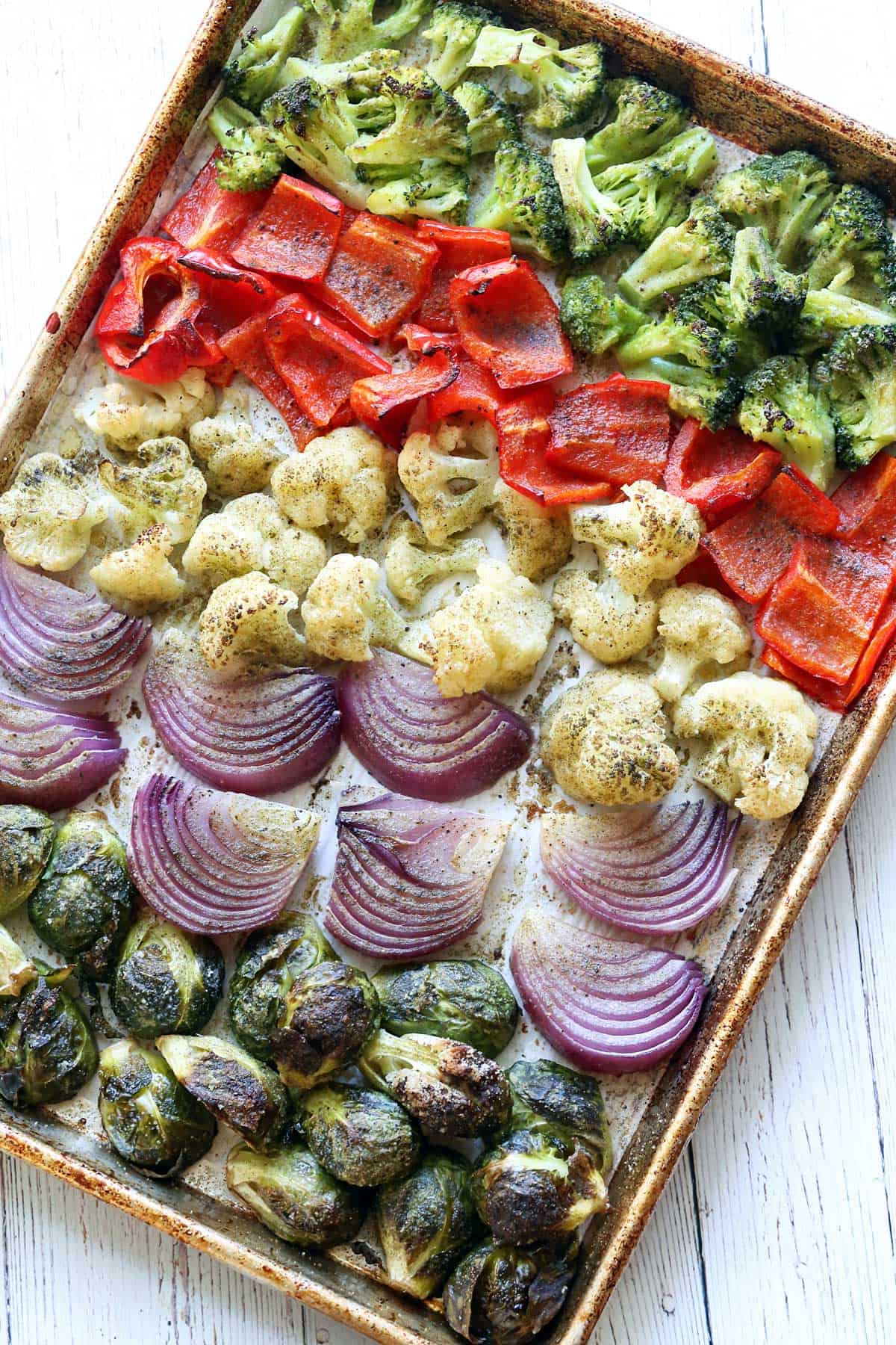 Roasted veggies on a parchment-lined baking sheet. 