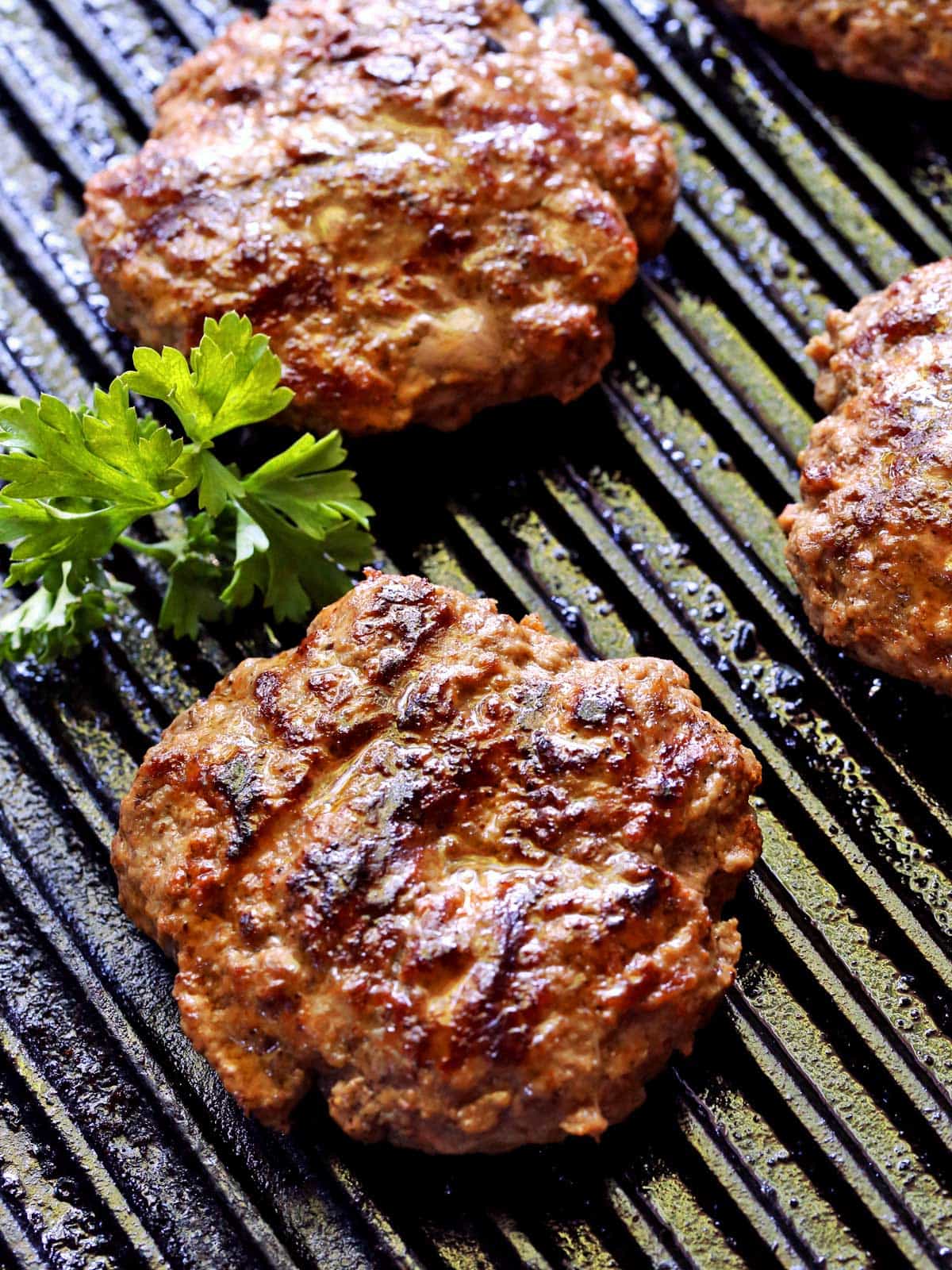 Grilled hamburgers photographed on the grill. 