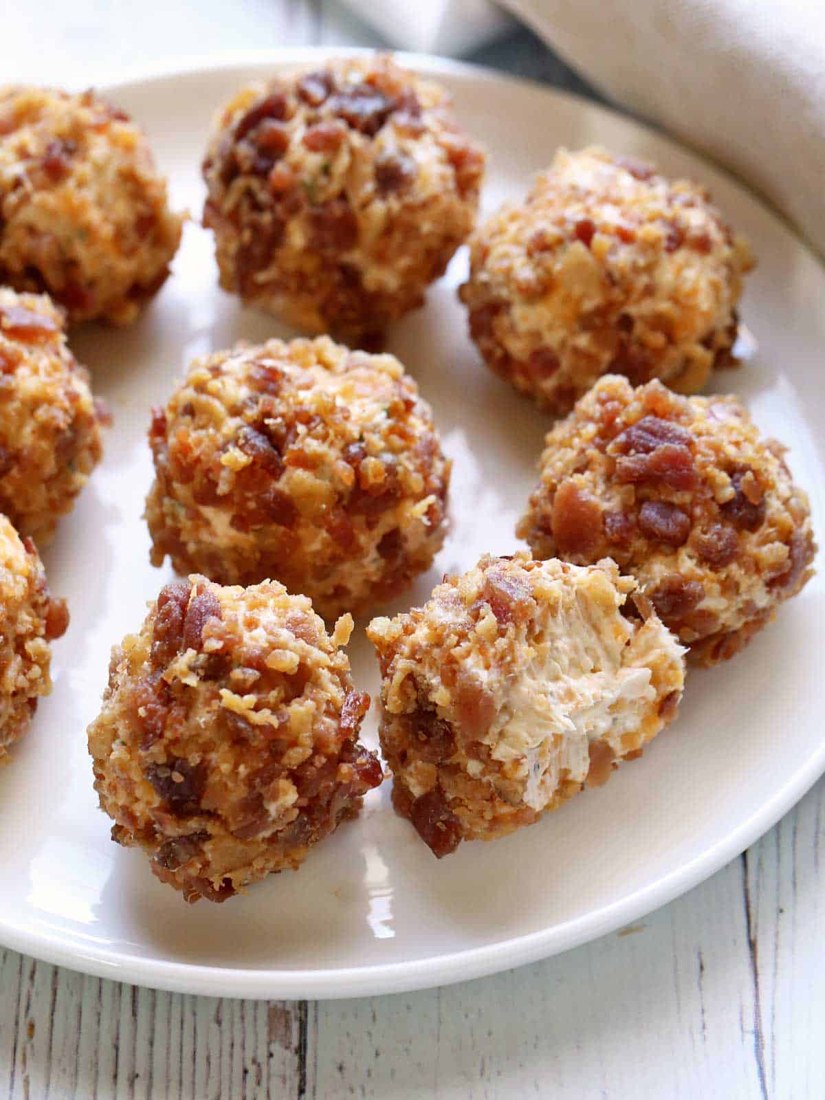 Cheese balls are served on a white plate. 