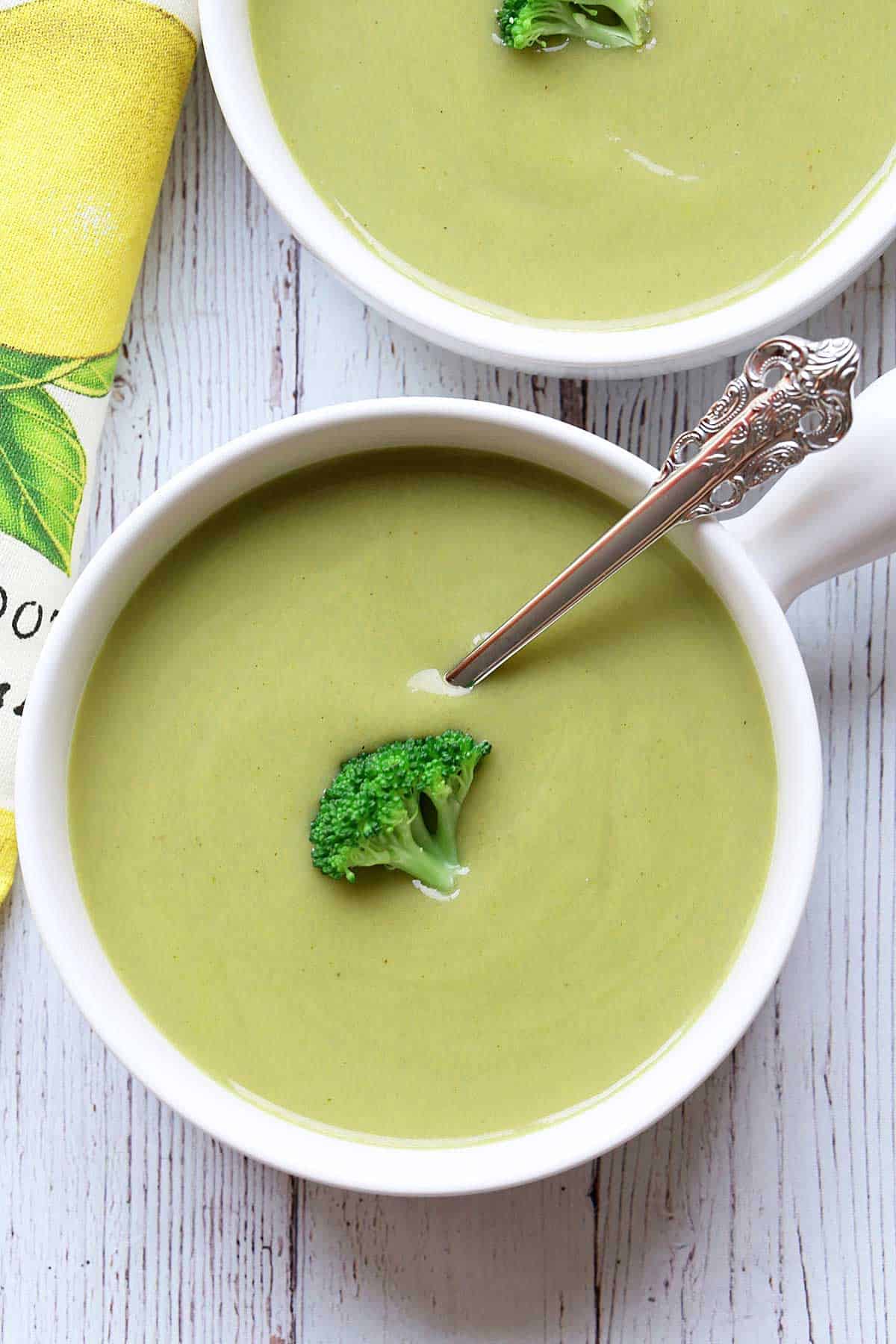 Cream of broccoli soup served in white bowls. 
