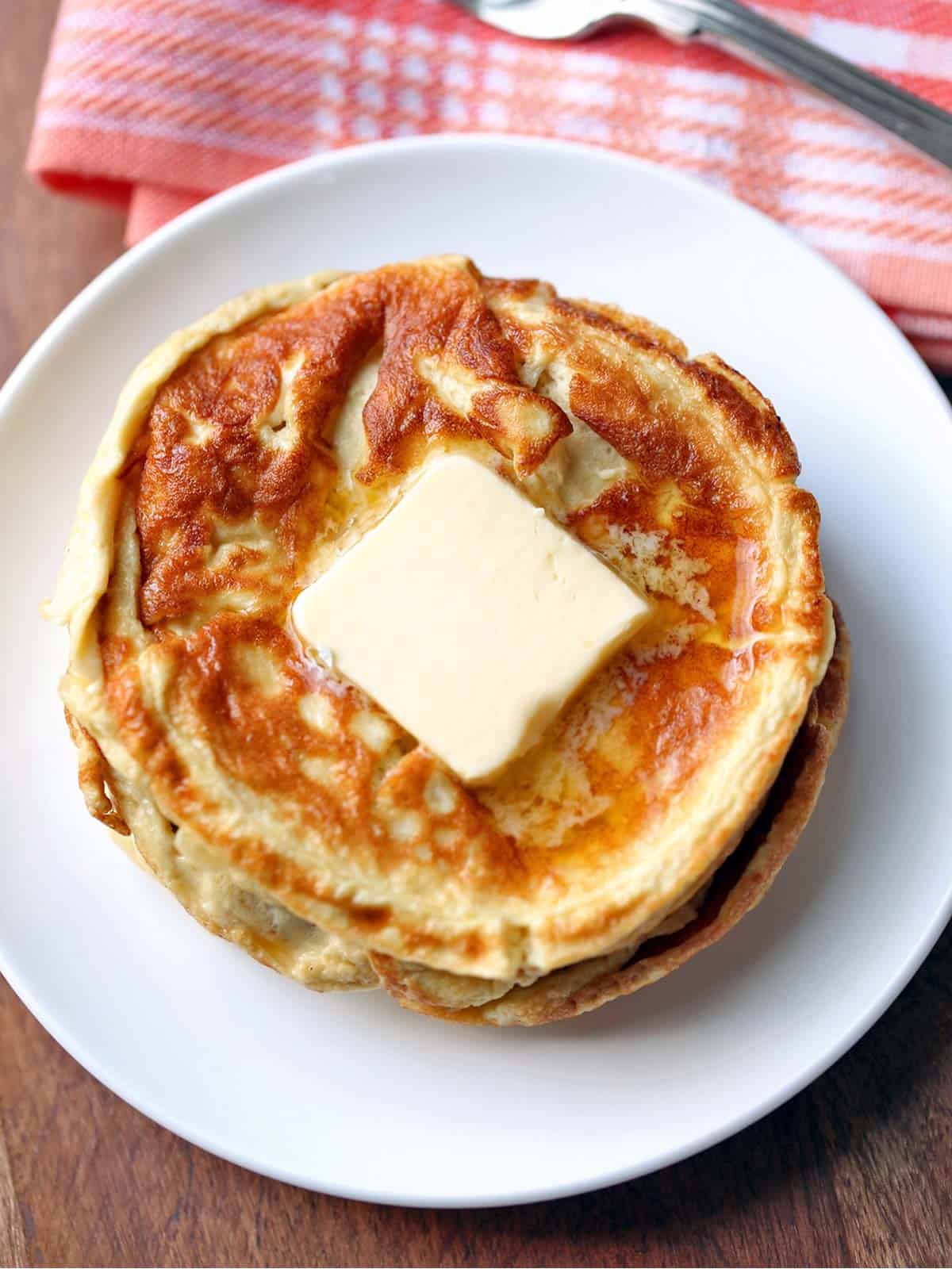 Keto cream cheese pancakes topped with butter. 