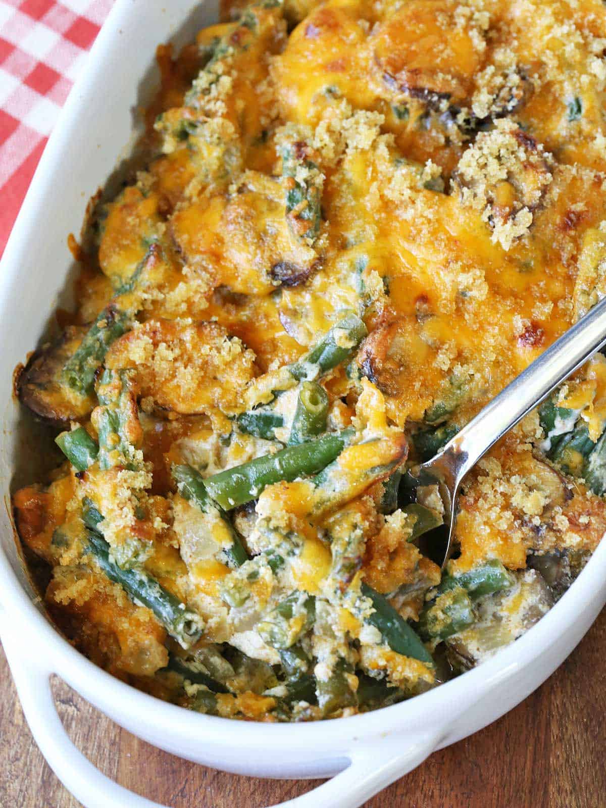 Keto green bean casserole served in a white baking dish with a serving spoon. 