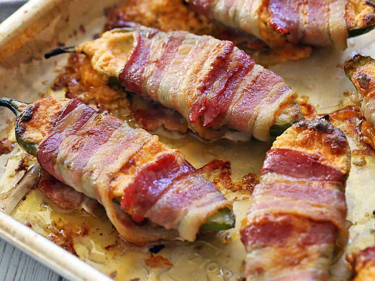 Bacon-wrapped jalapeno poppers photographed in the baking dish. 
