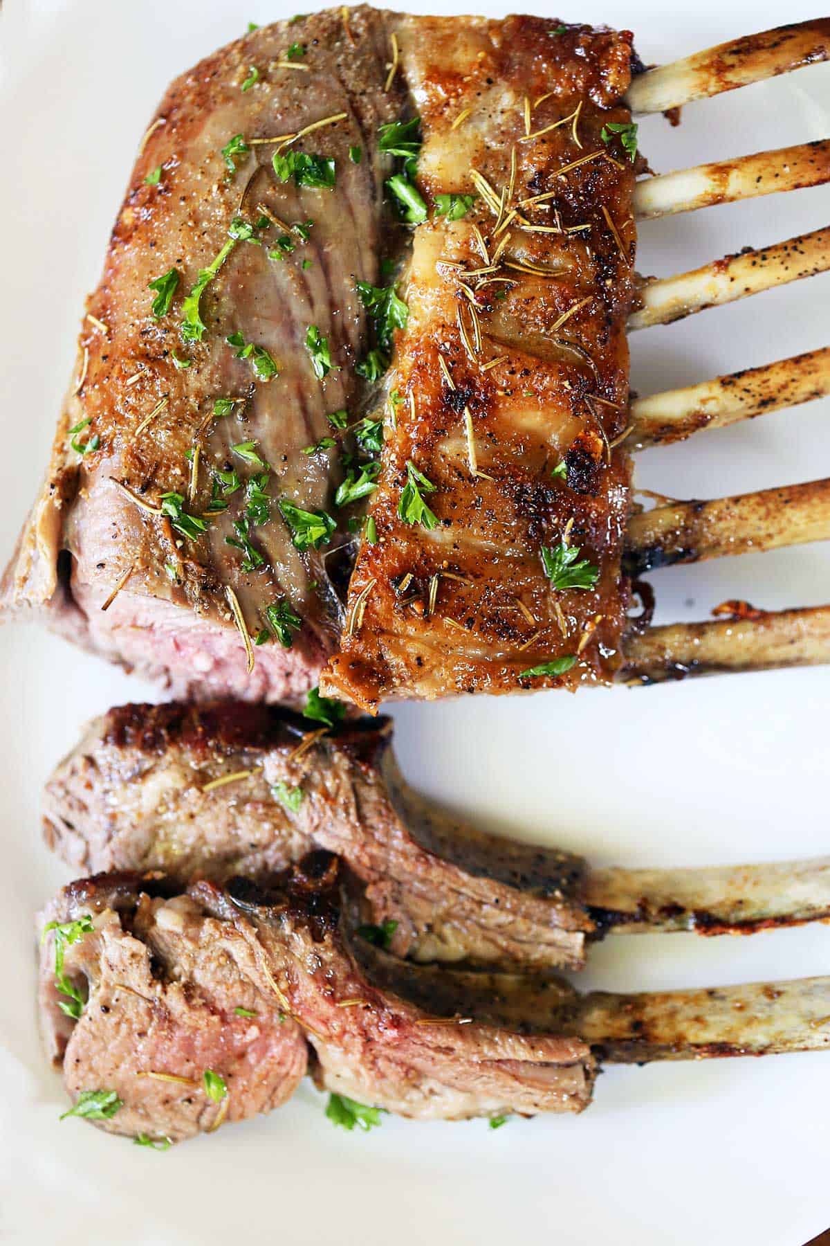 Sliced rack of lamb topped with chopped parsley. 
