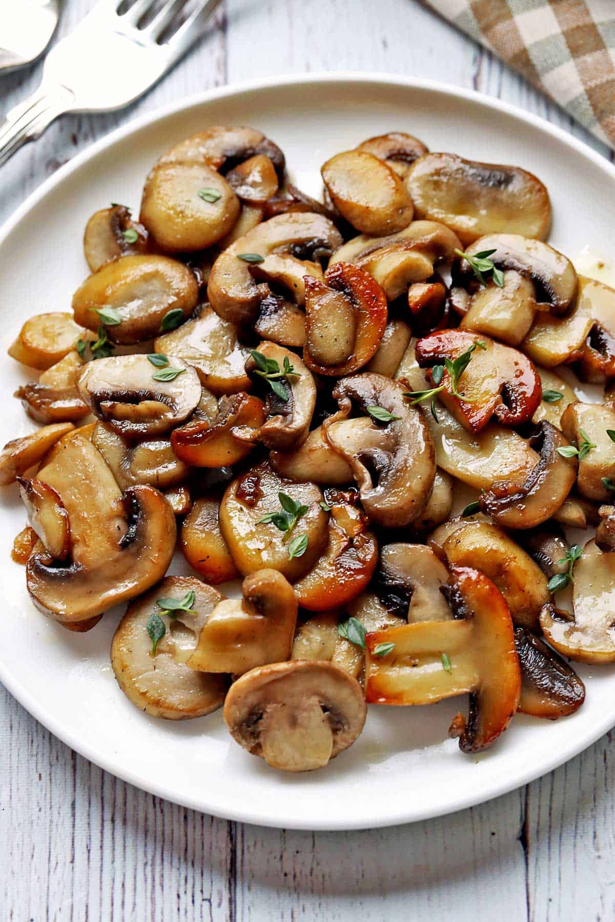 Sauteed mushrooms served on a white plate. 
