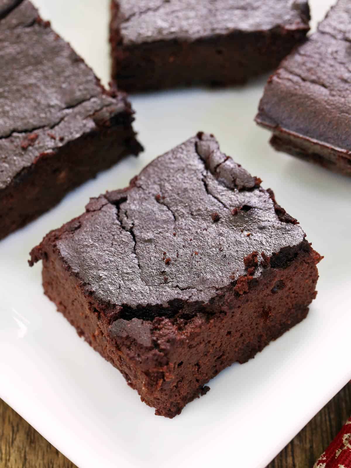 Keto brownies are served on a white plate. 