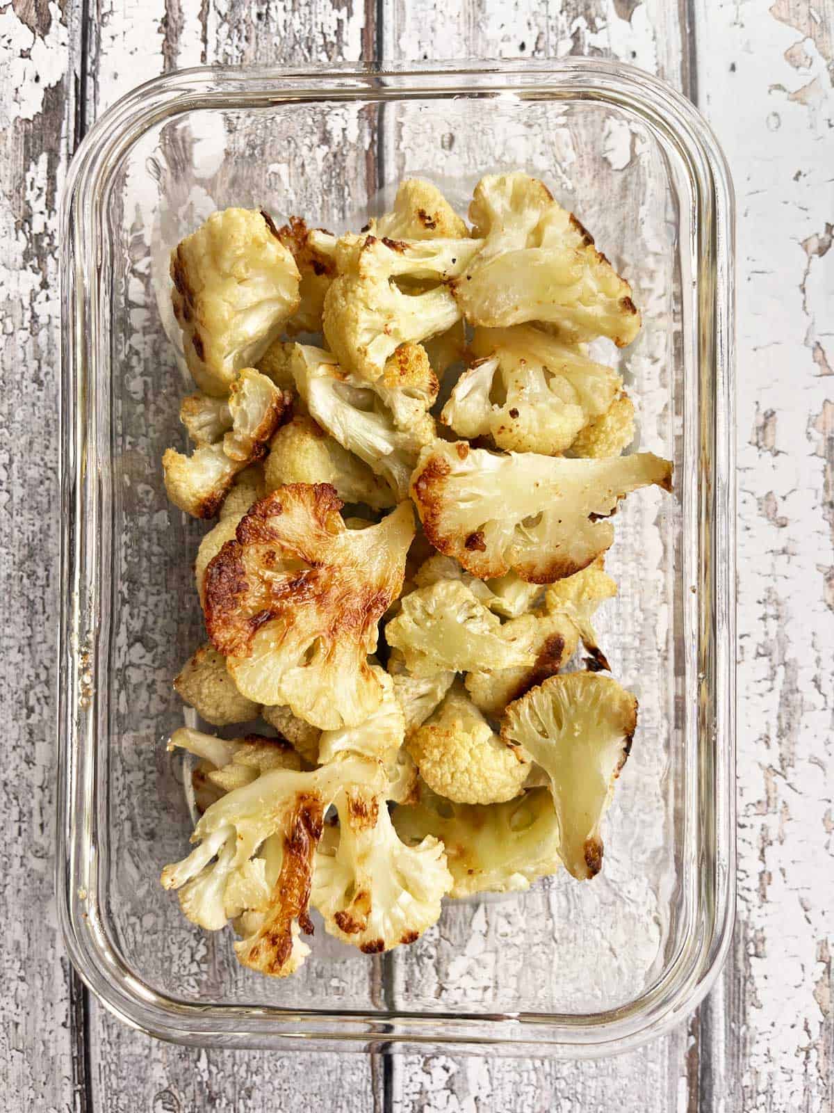 Roasted cauliflower leftovers stored in a glass container. 