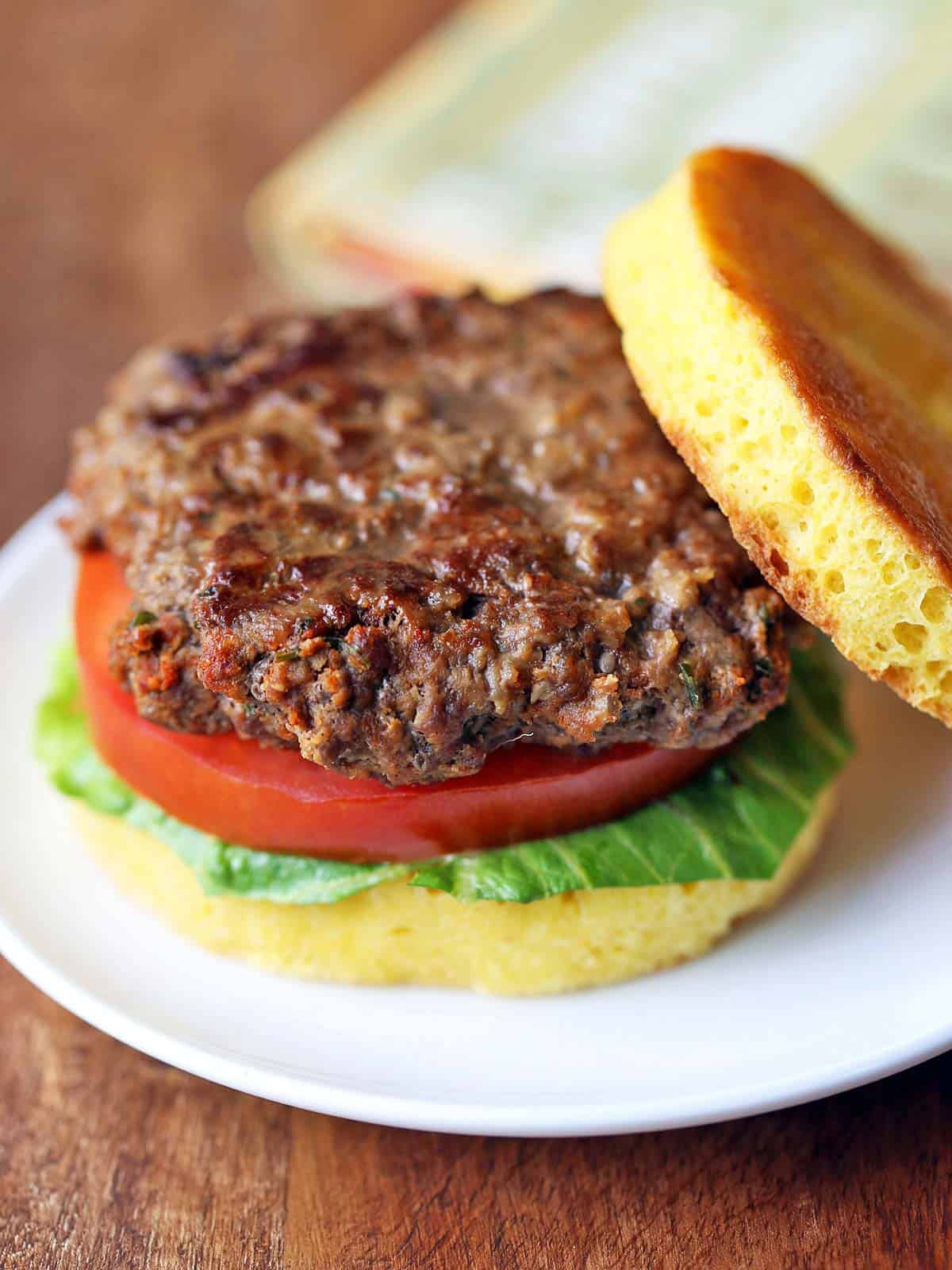 Bison burger served on a bun with lettuce and tomato. 