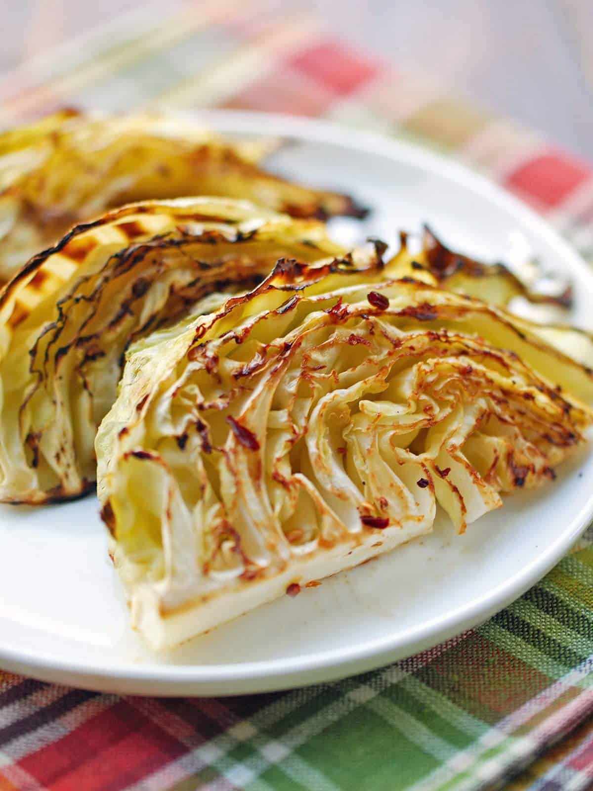 Roasted cabbage served on a white plate. 