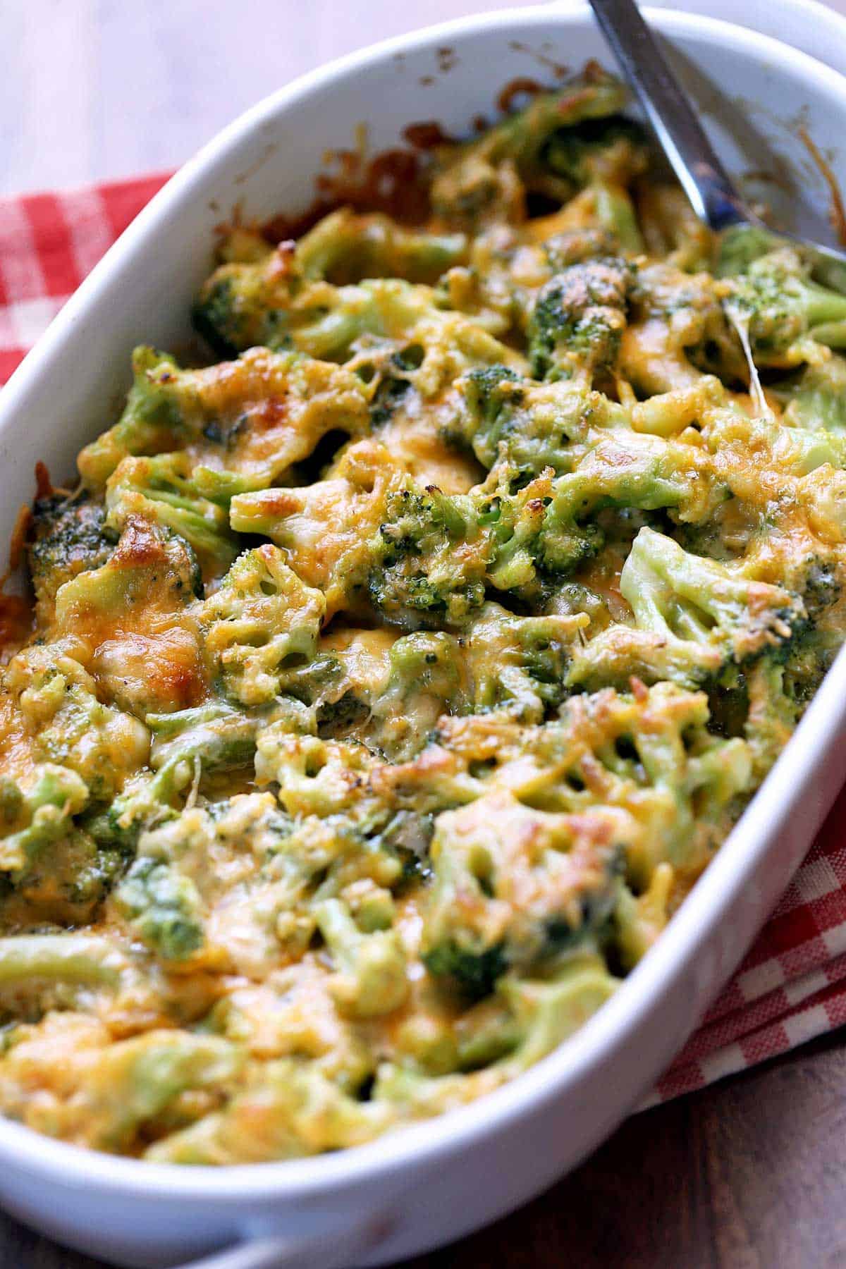 Broccoli cheese casserole served in a white oval baking dish. 