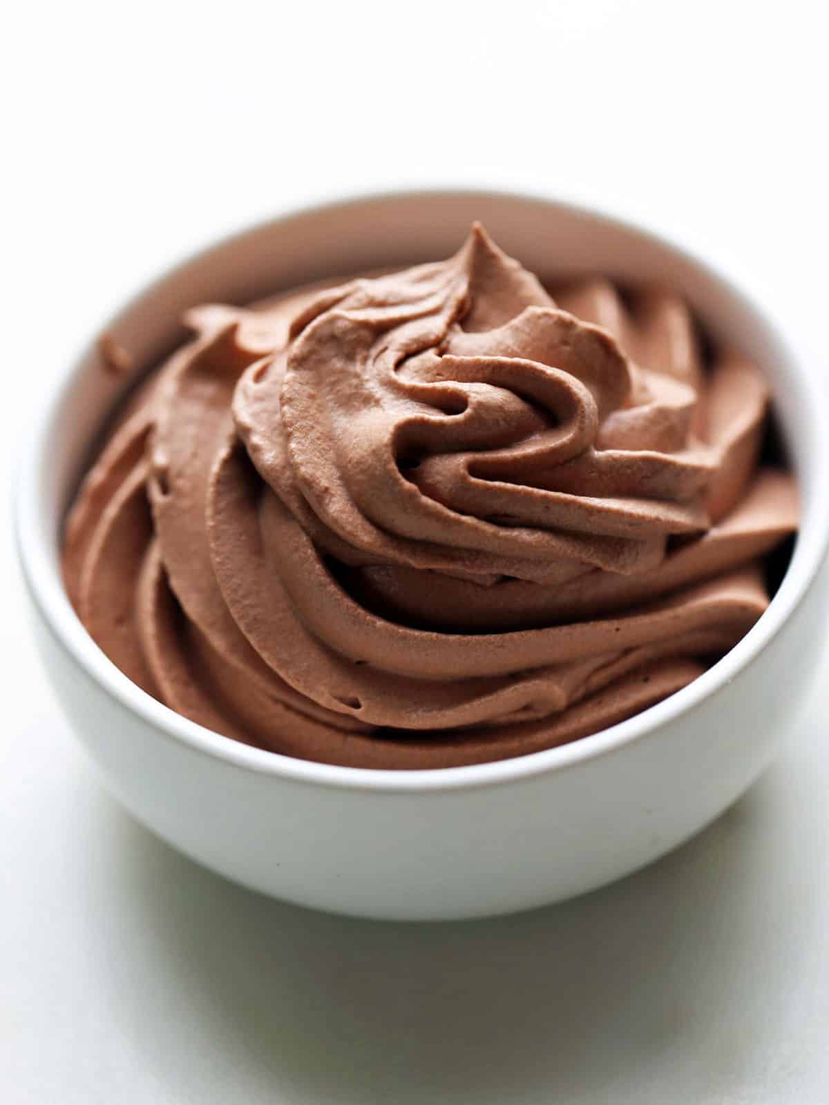 Keto chocolate whipped cream is served in a white bowl. 