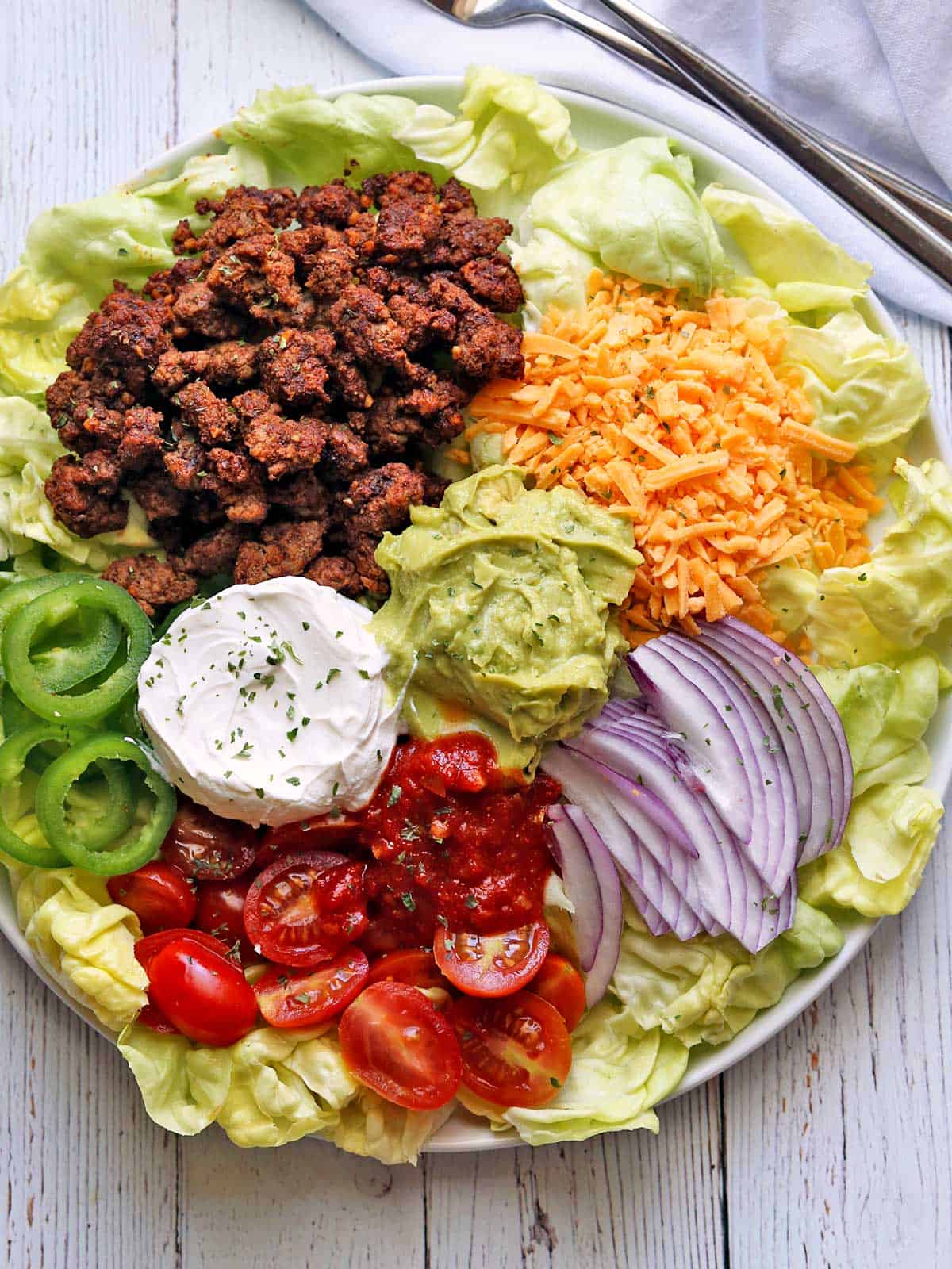Keto taco salad served on a white plate. 