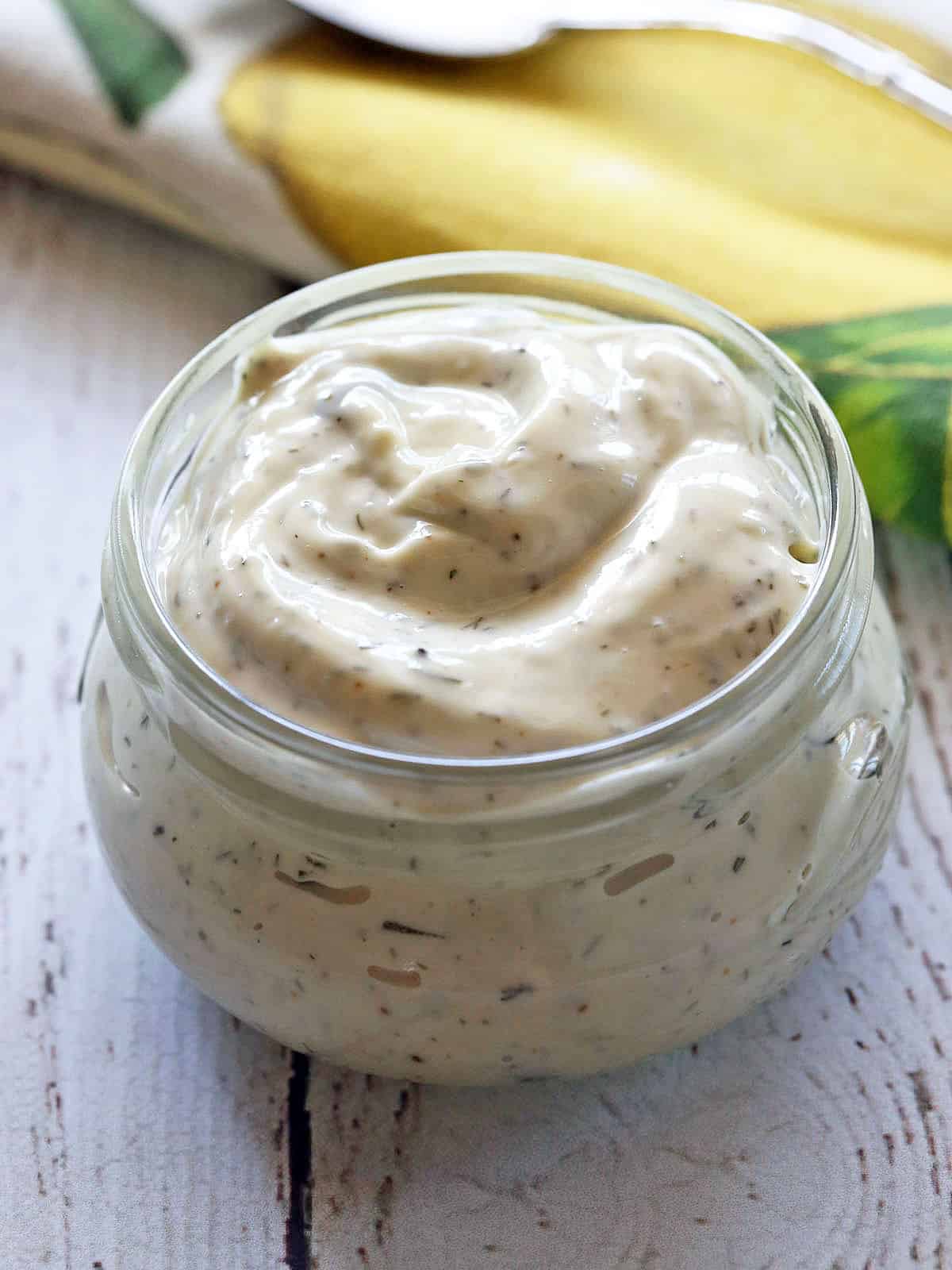 Homemade tartar sauce served in a jar with a spoon. 