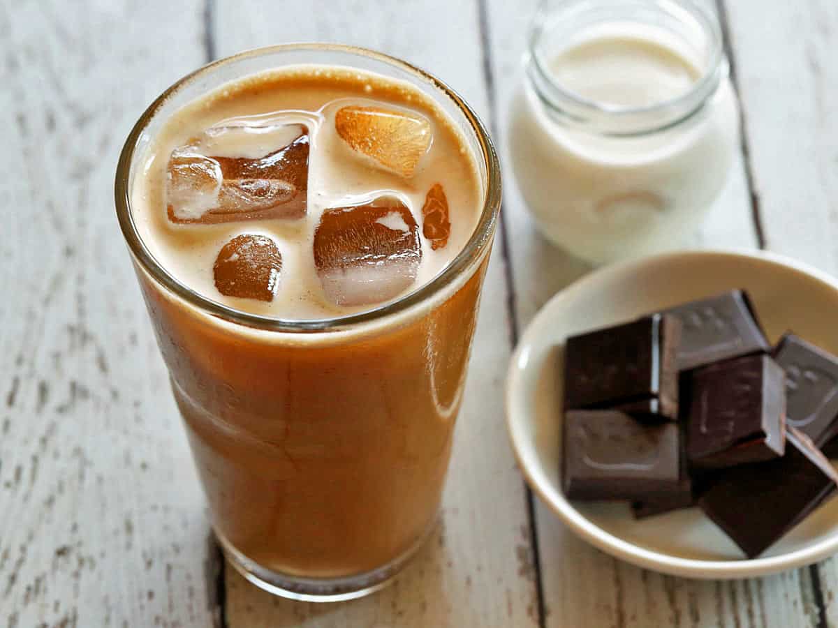 Iced coffee served in a tall glass with heavy cream and dark chocolate. 