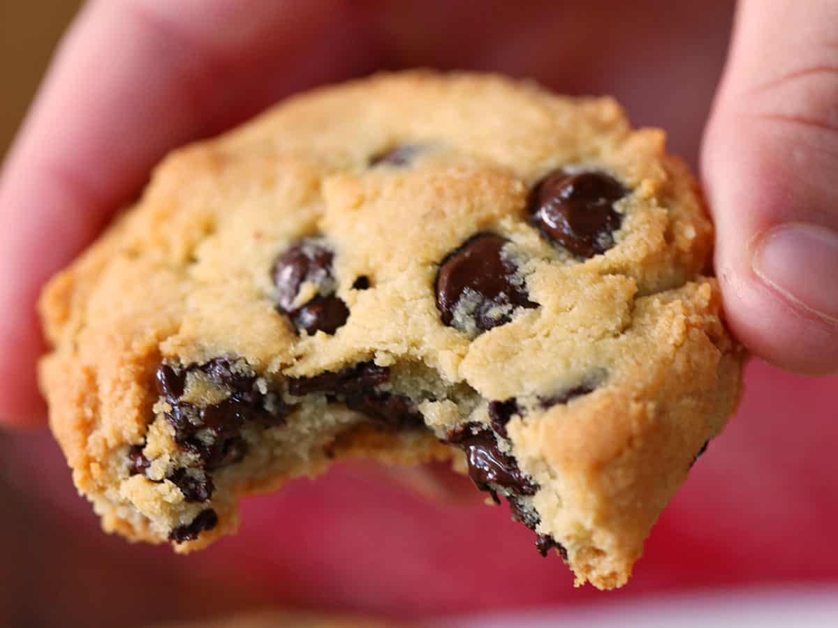 Keto chocolate chip cookie held in the air. 
