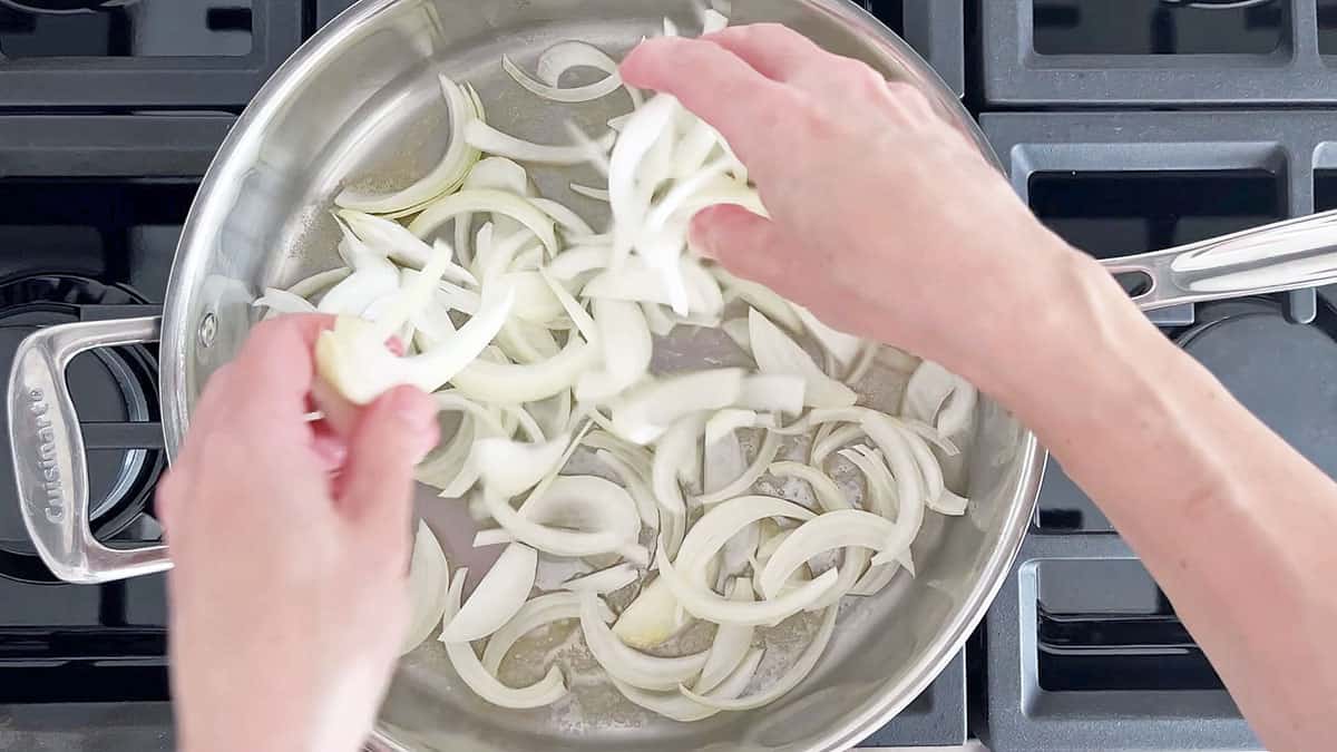 Adding the onions to the skillet. 