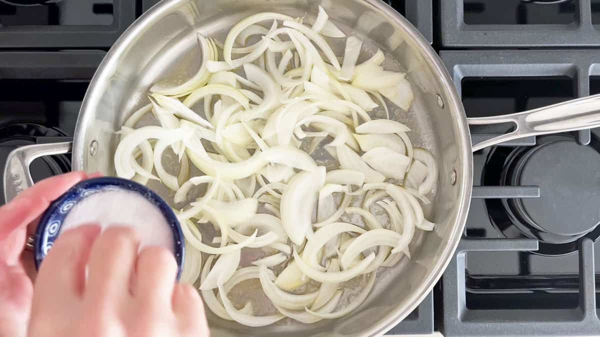 Sprinkling the onions in the skillet with salt. 