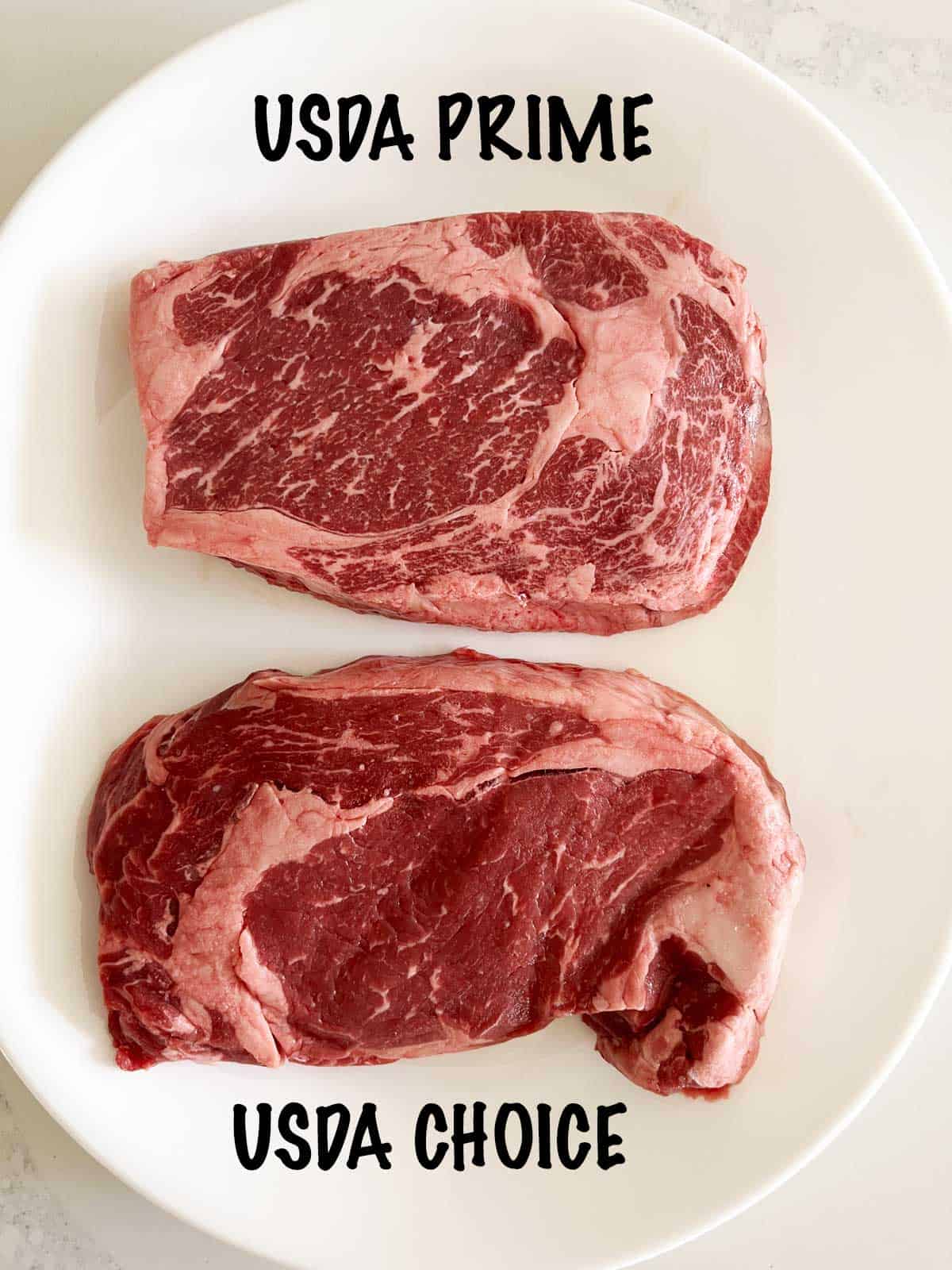 Prime and Choice ribeye steaks on a white plate. 