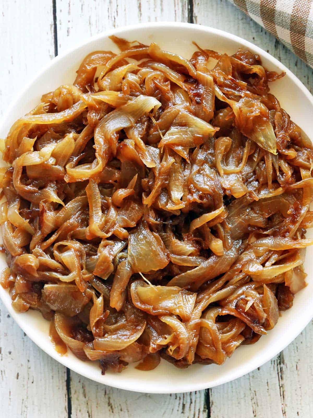 Caramelized onions served on a white plate with a napkin.