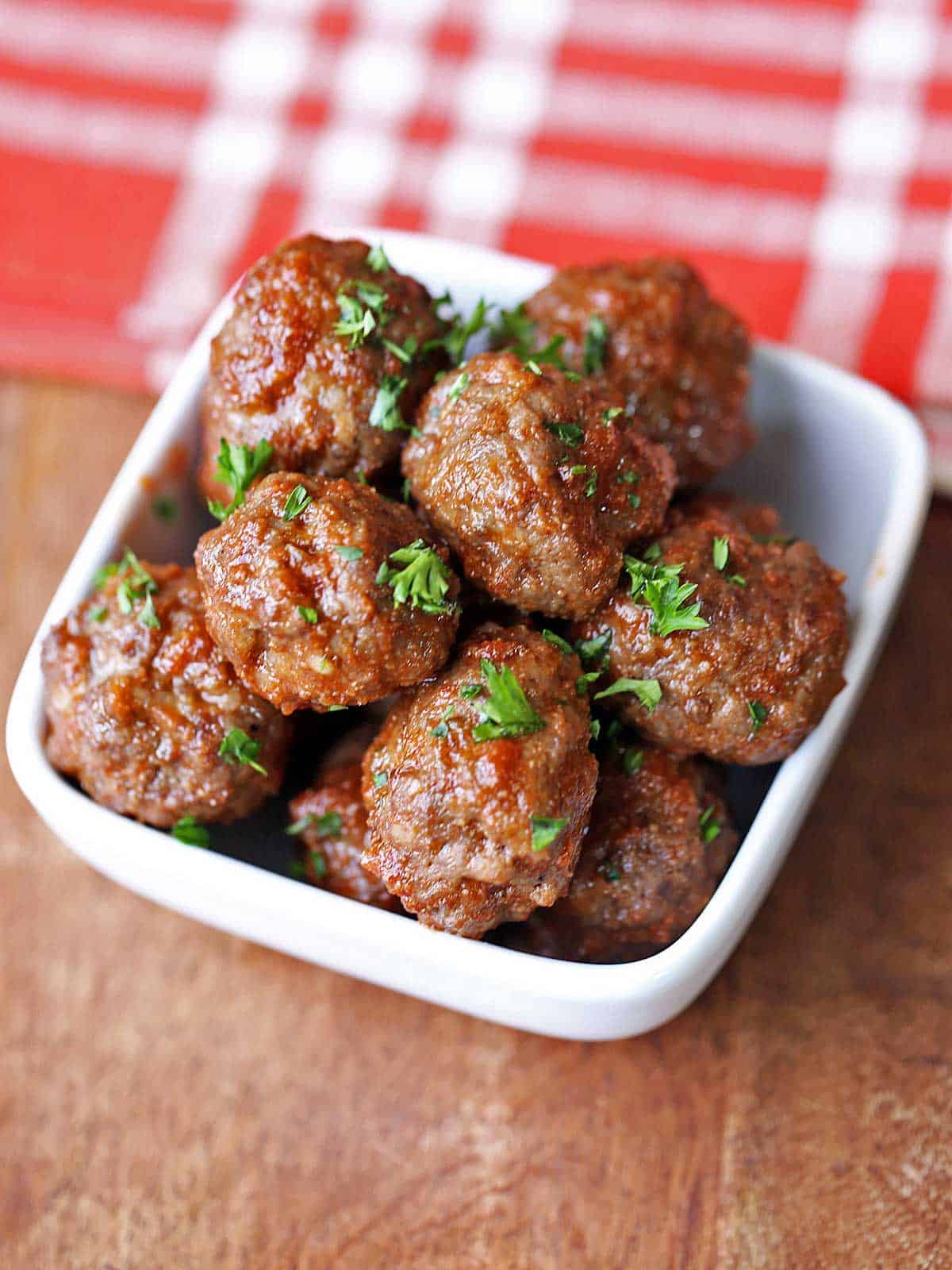 Baked meatballs garnished with chopped parsley. 